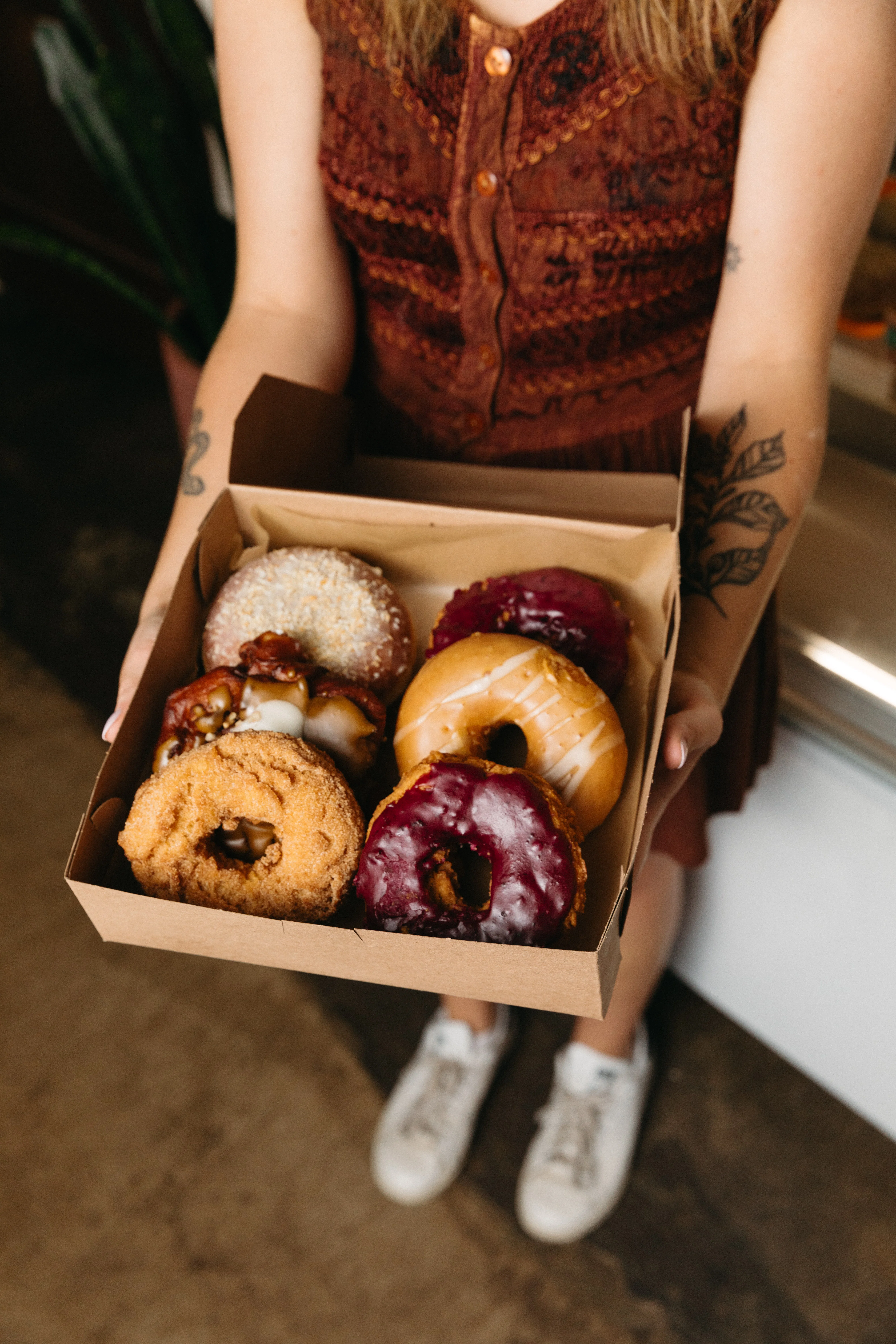 A tray with four colorful donuts, featuring various icing and toppings.