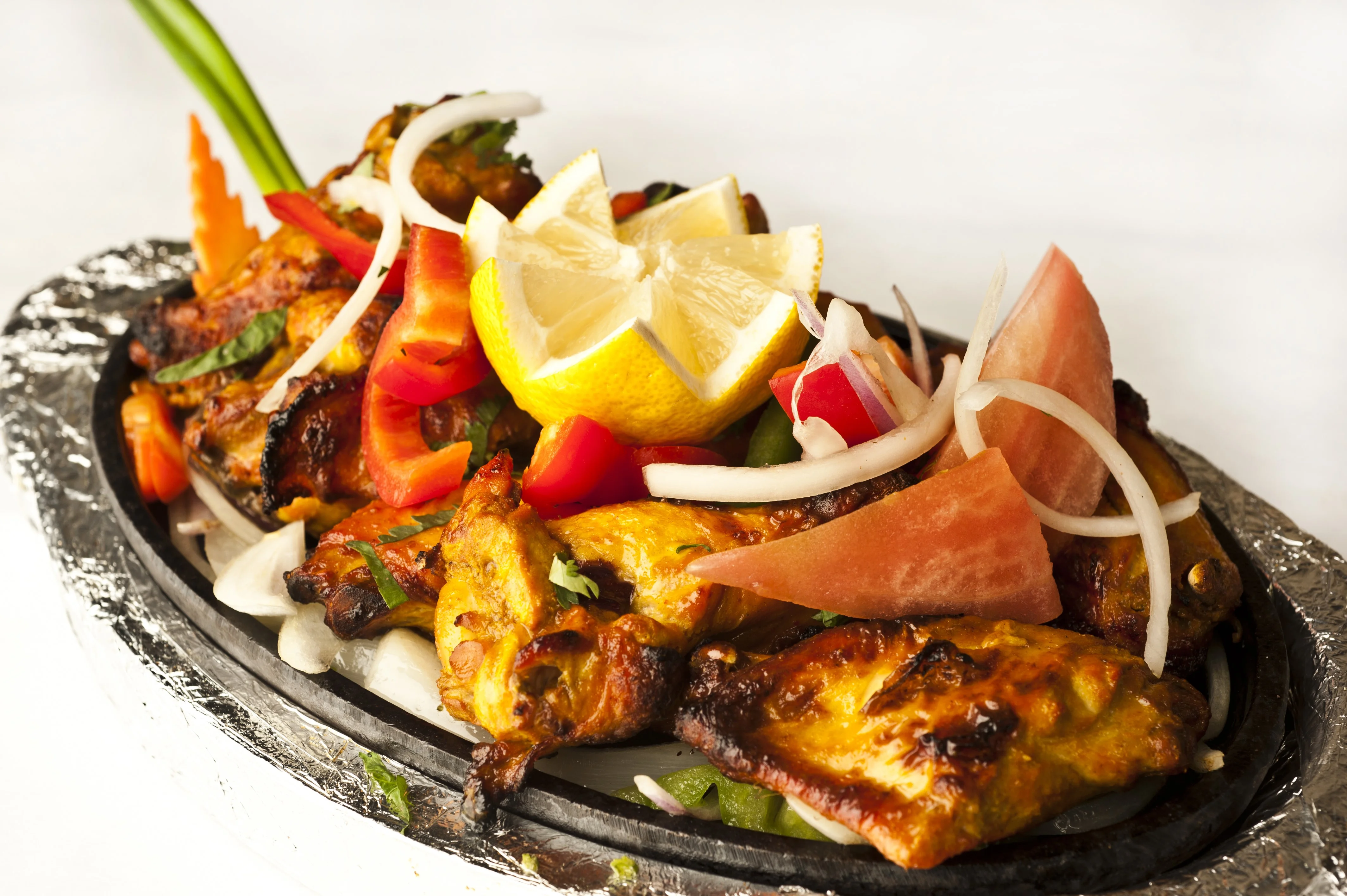 Sizzling Indian tandoori chicken served with fresh vegetables