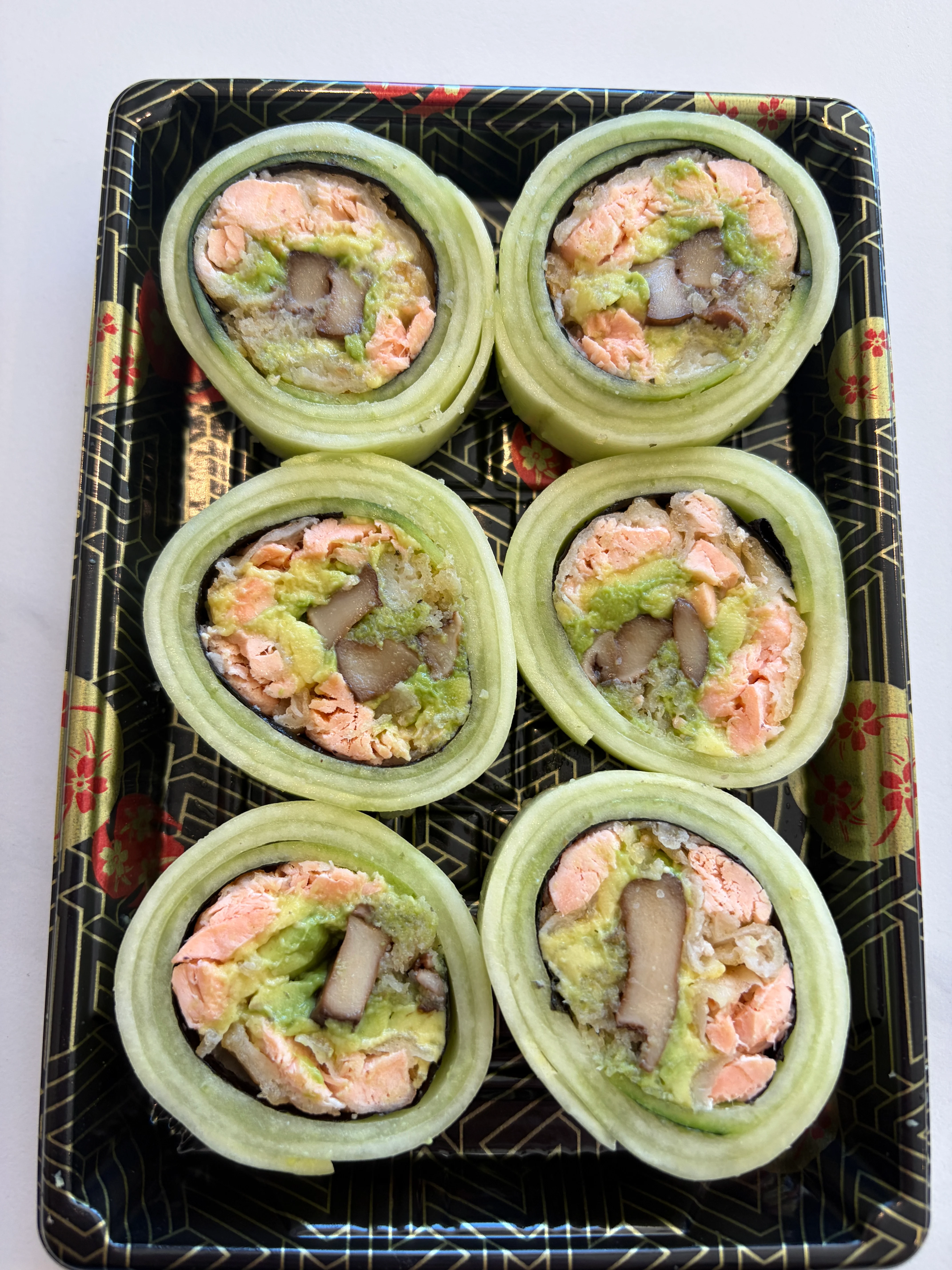 Japanese sushi rolls with salmon and avocado wrapped in cucumber