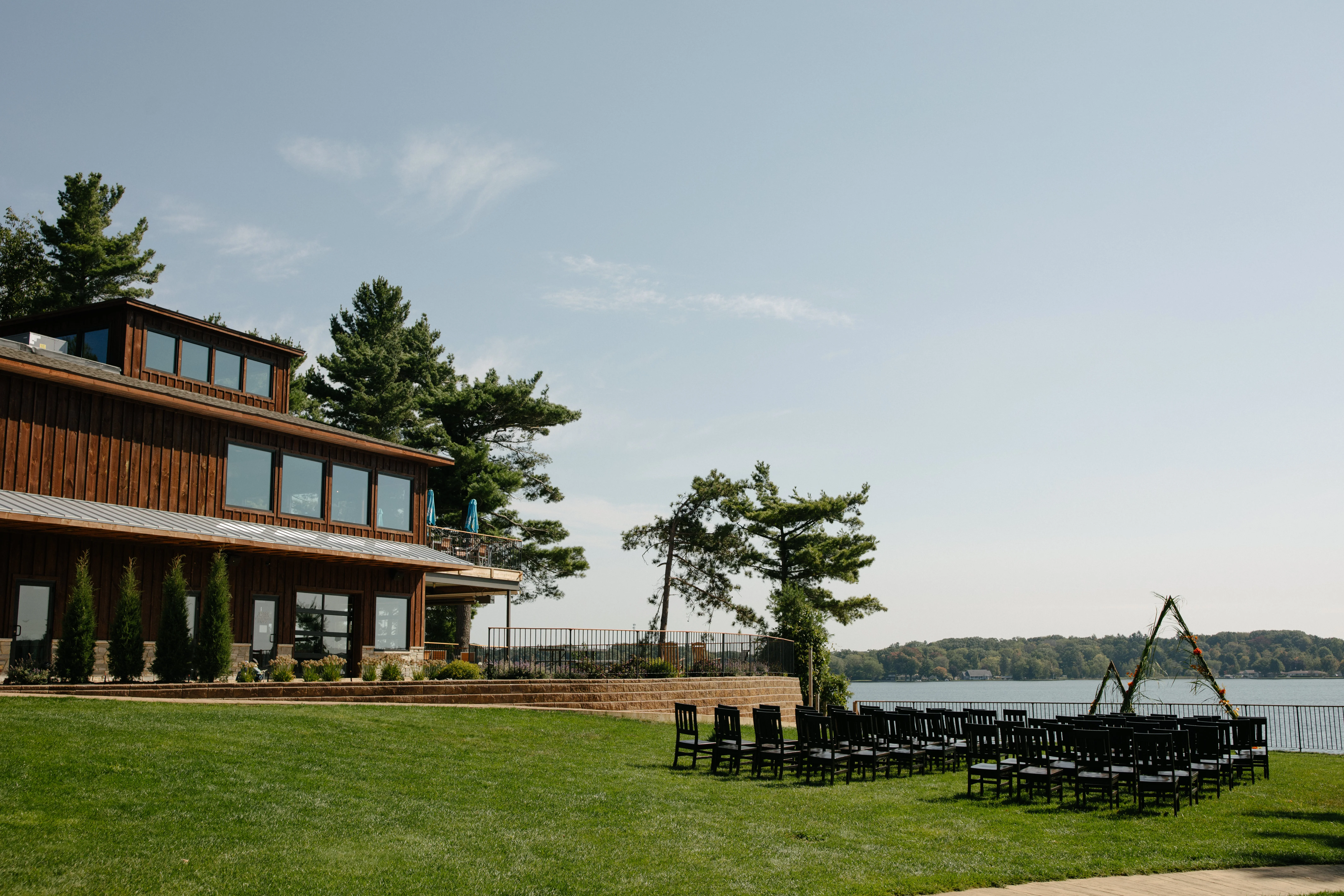 Outdoor wedding venue by the lake with chairs and a wooden building