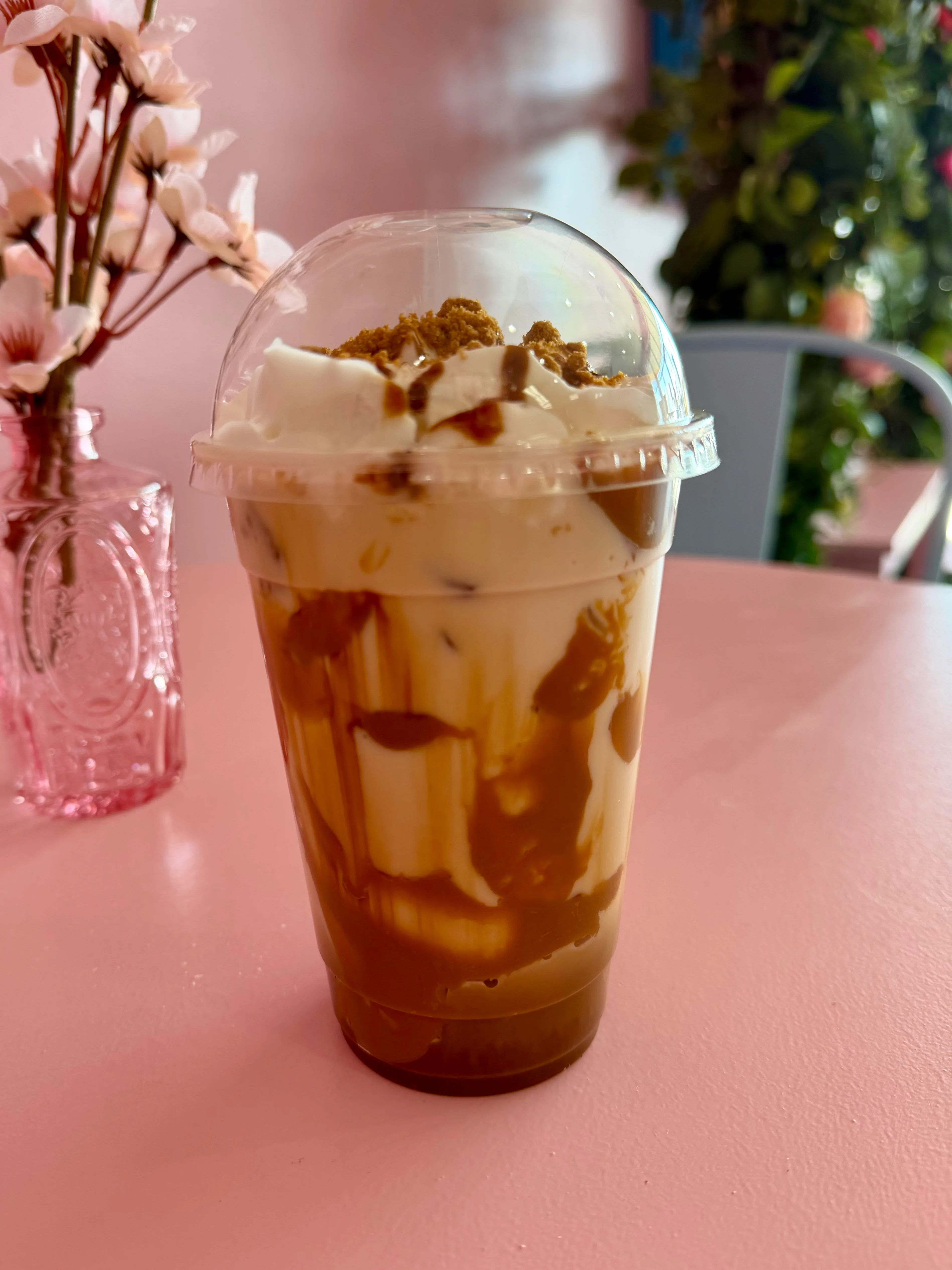 Iced coffee drink topped with whipped cream and cookie crumbles.