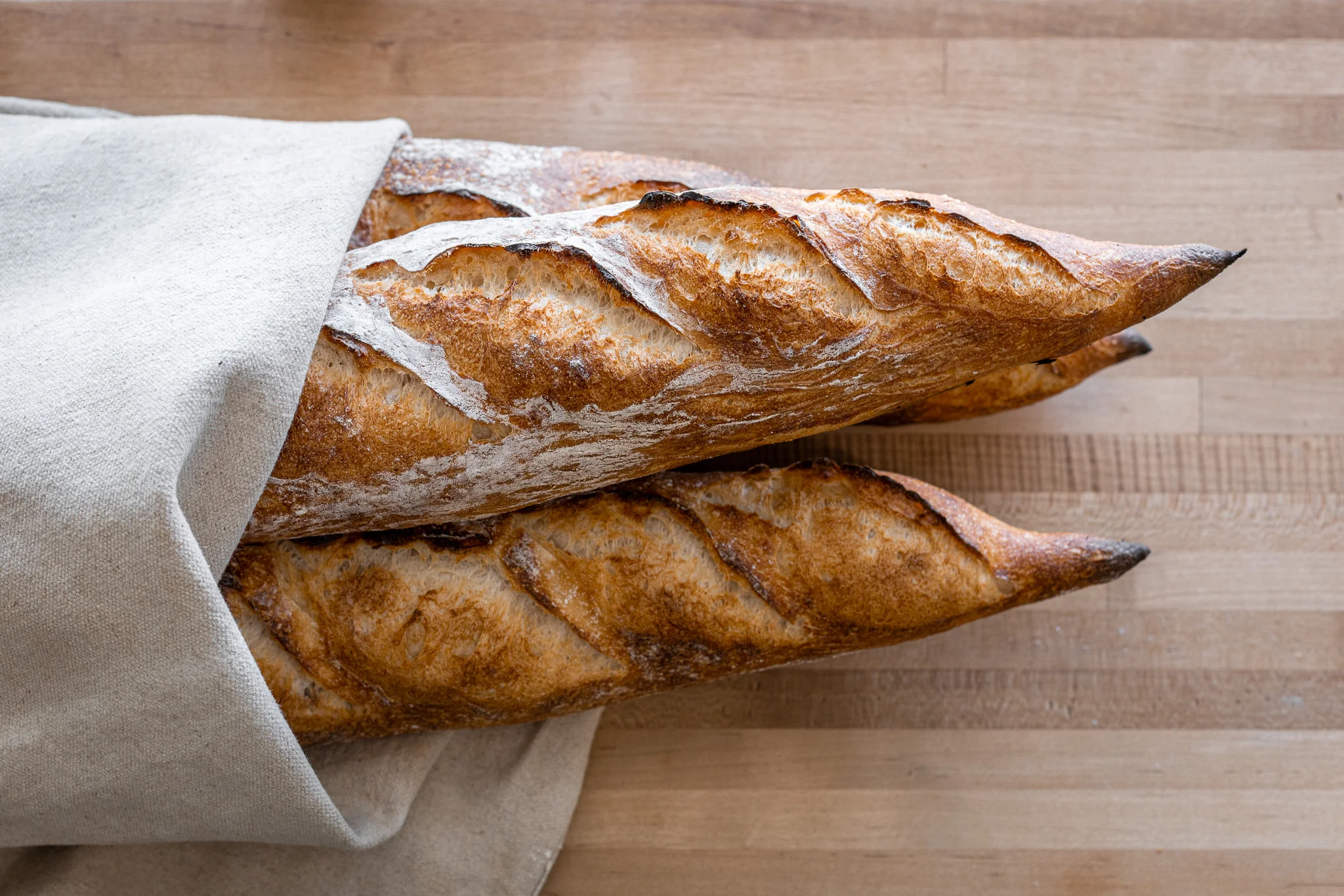 Freshly baked French baguettes wrapped in linen