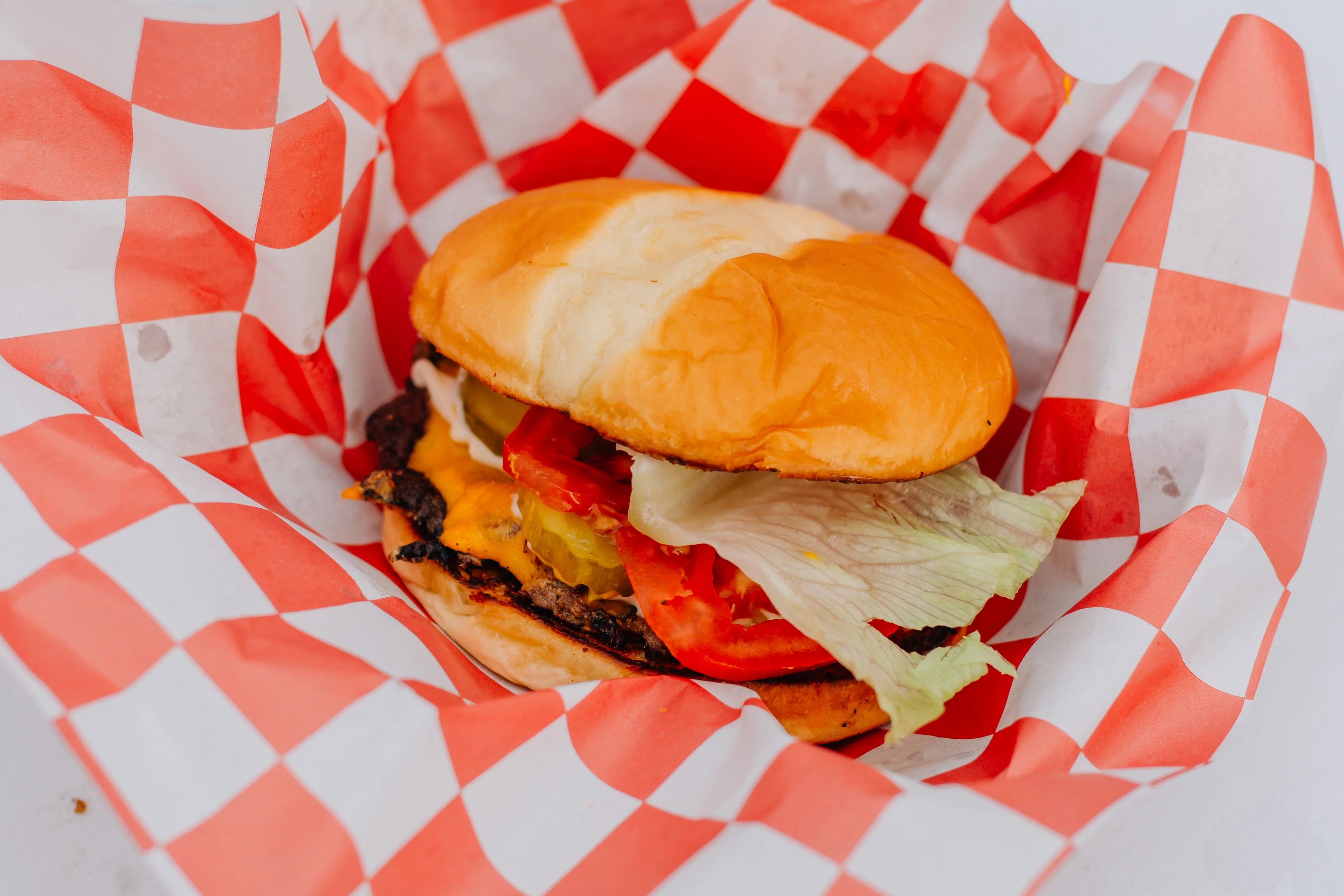 Classic American cheeseburger in a checkered paper wrap