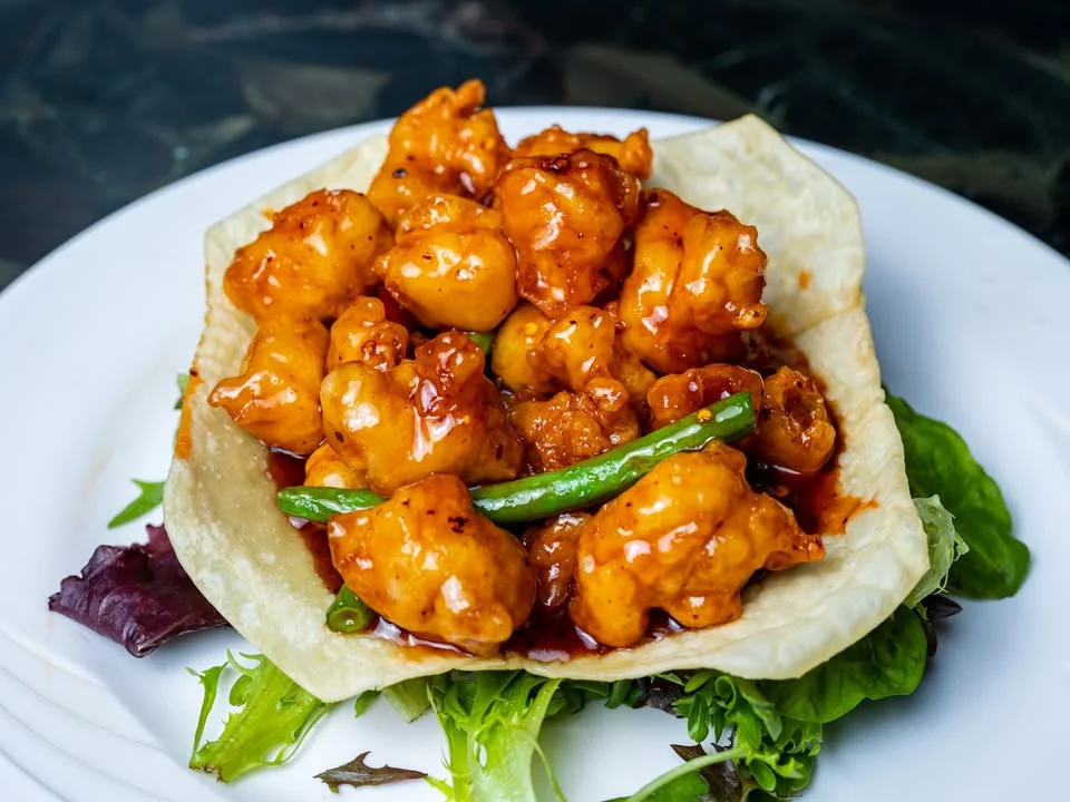 Sweet and sour General Tso's chicken served in a crispy tortilla bowl