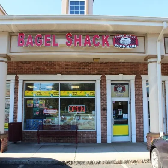 Bagel shop exterior with bright signage and open door