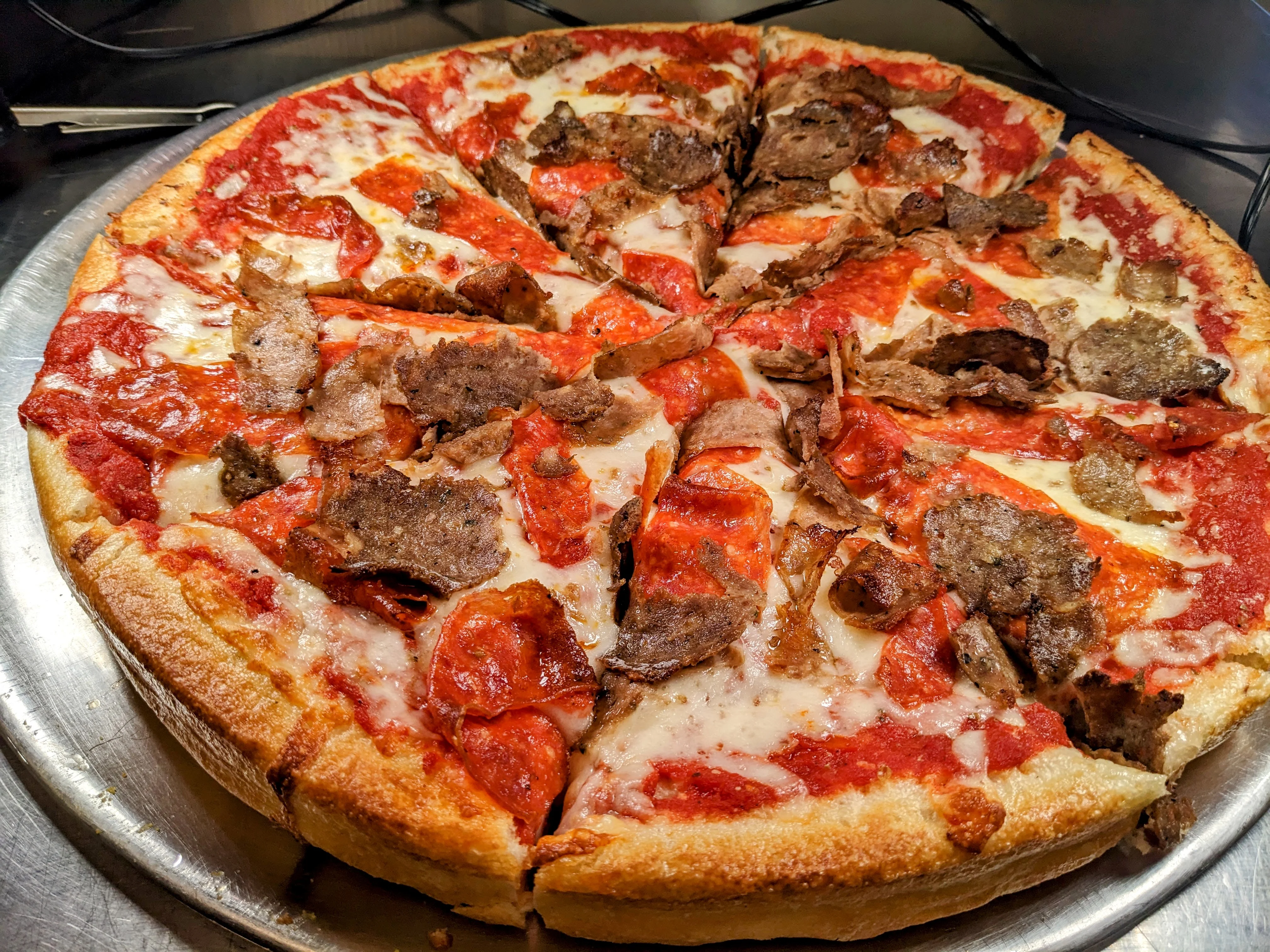 Delicious pizza topped with pepperoni and gyro meat