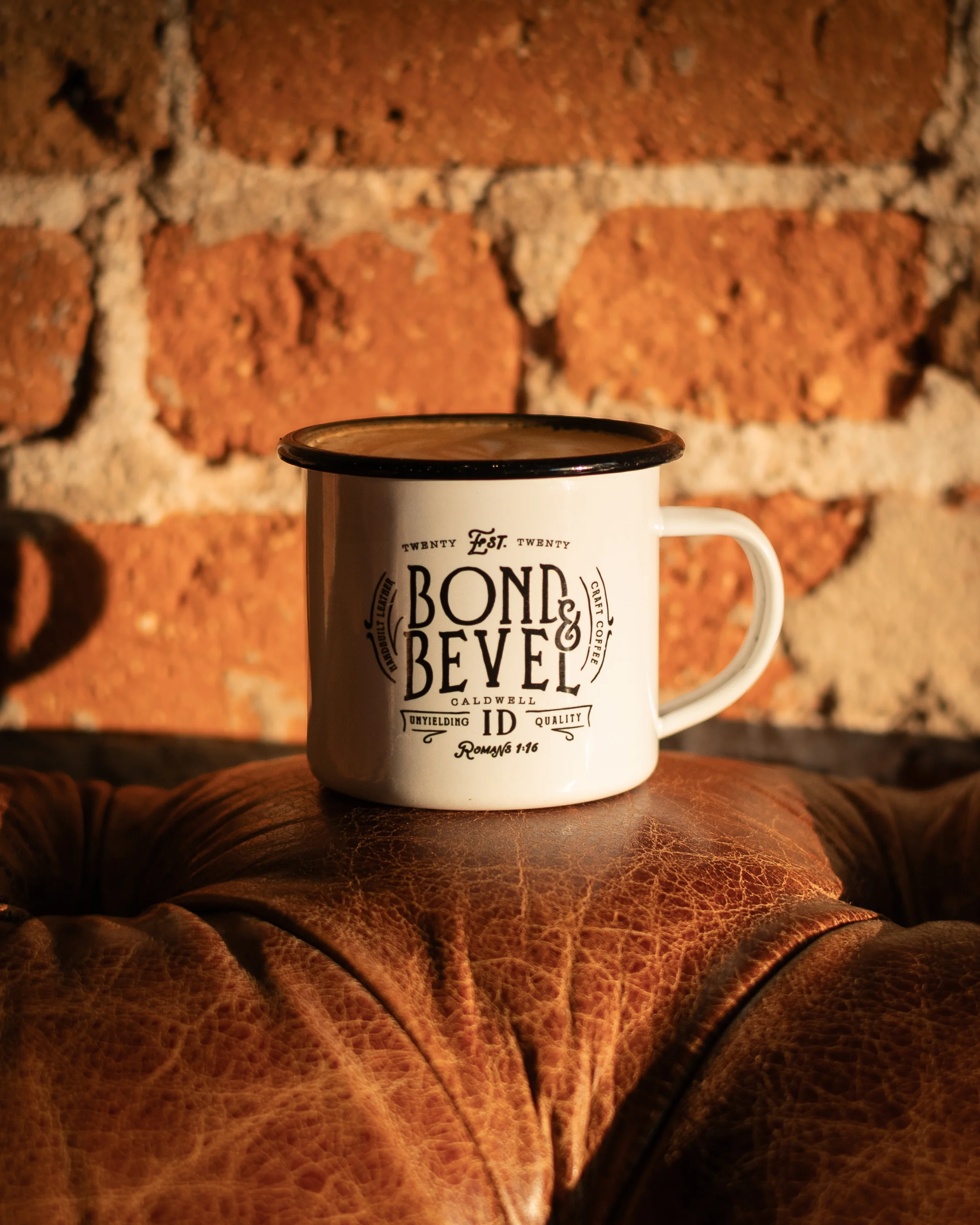 Vintage enamel mug on leather couch with brick wall background