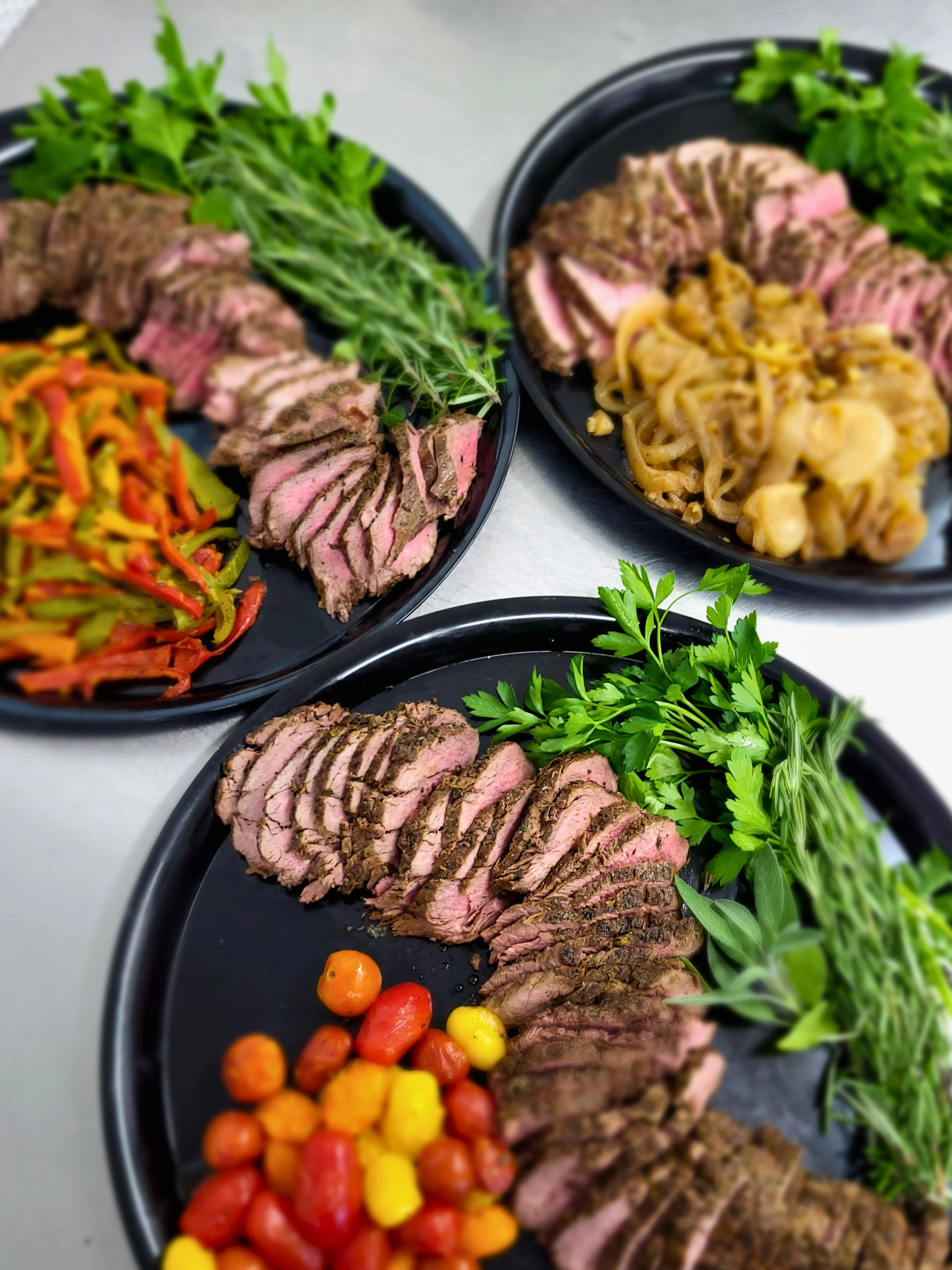 Sliced herb-crusted beef with colorful vegetables