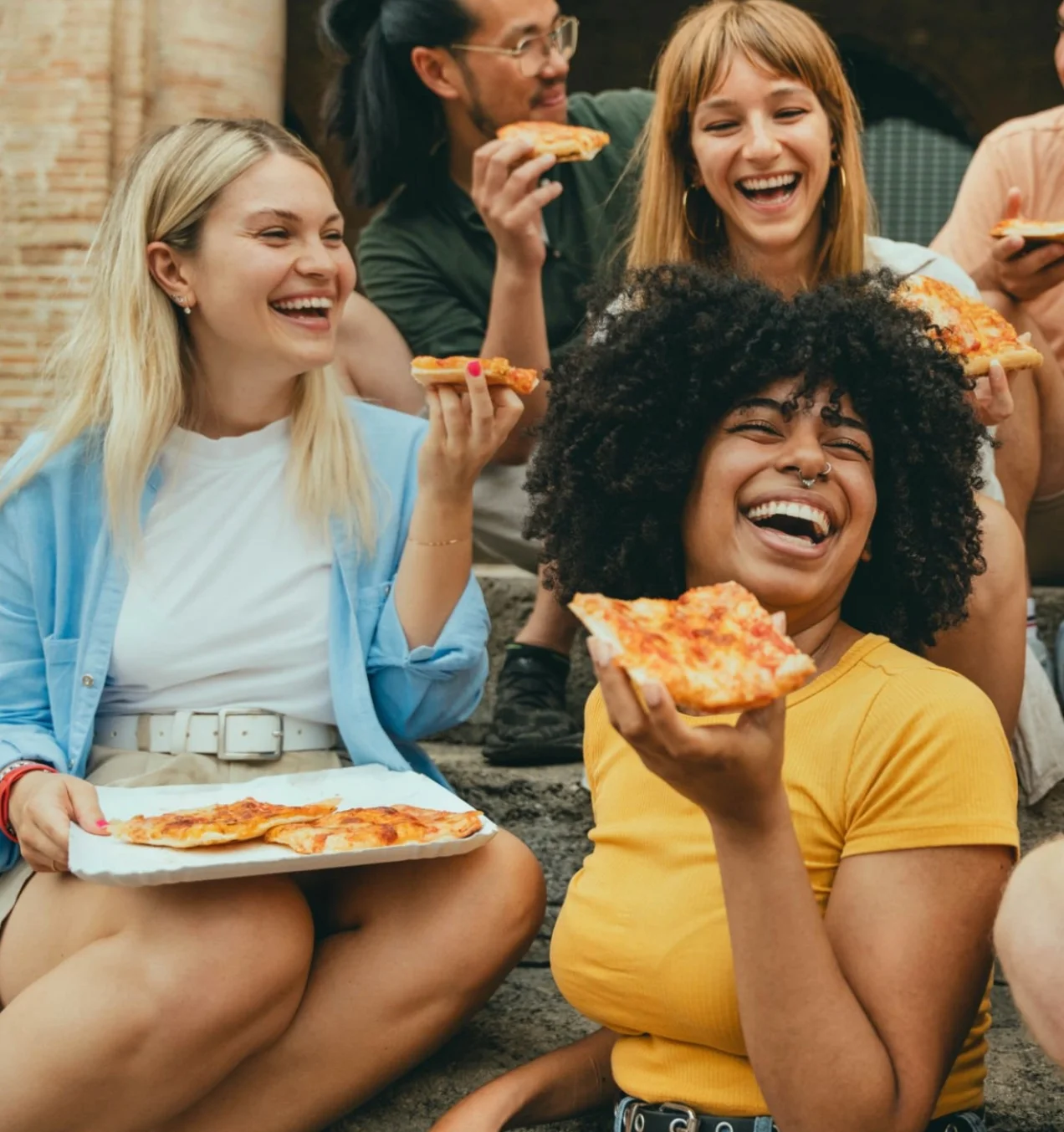 Group of friends enjoying Margherita pizza outdoors