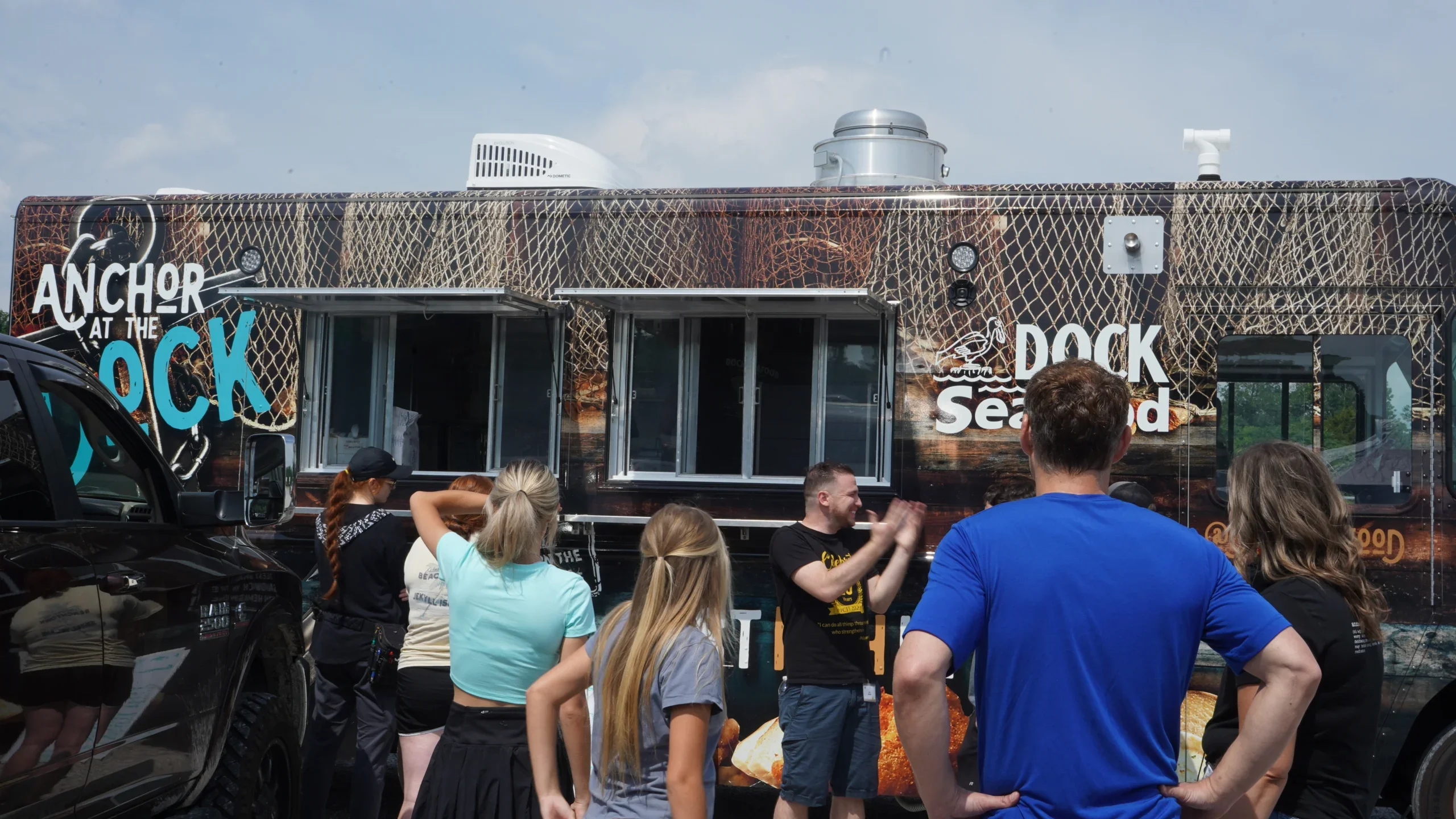 Food truck serving seafood dishes at a busy outdoor event