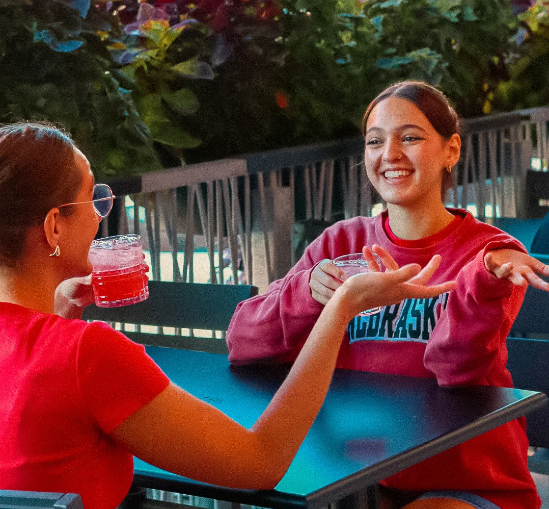 two people sitting outside on Fleetwood's patio enjoying a cocktail