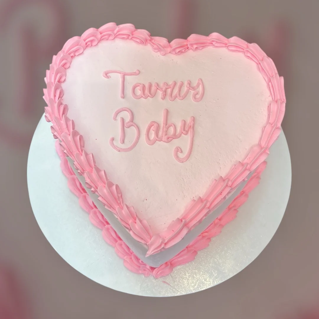 Heart-shaped pink birthday cake with decorative icing
