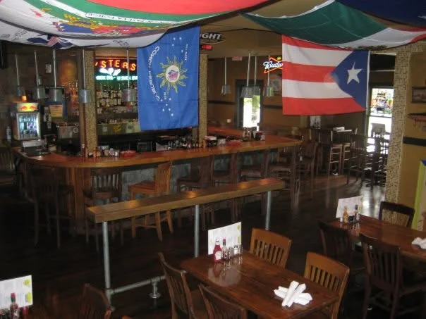 Cozy restaurant interior with flags and wooden bar seating