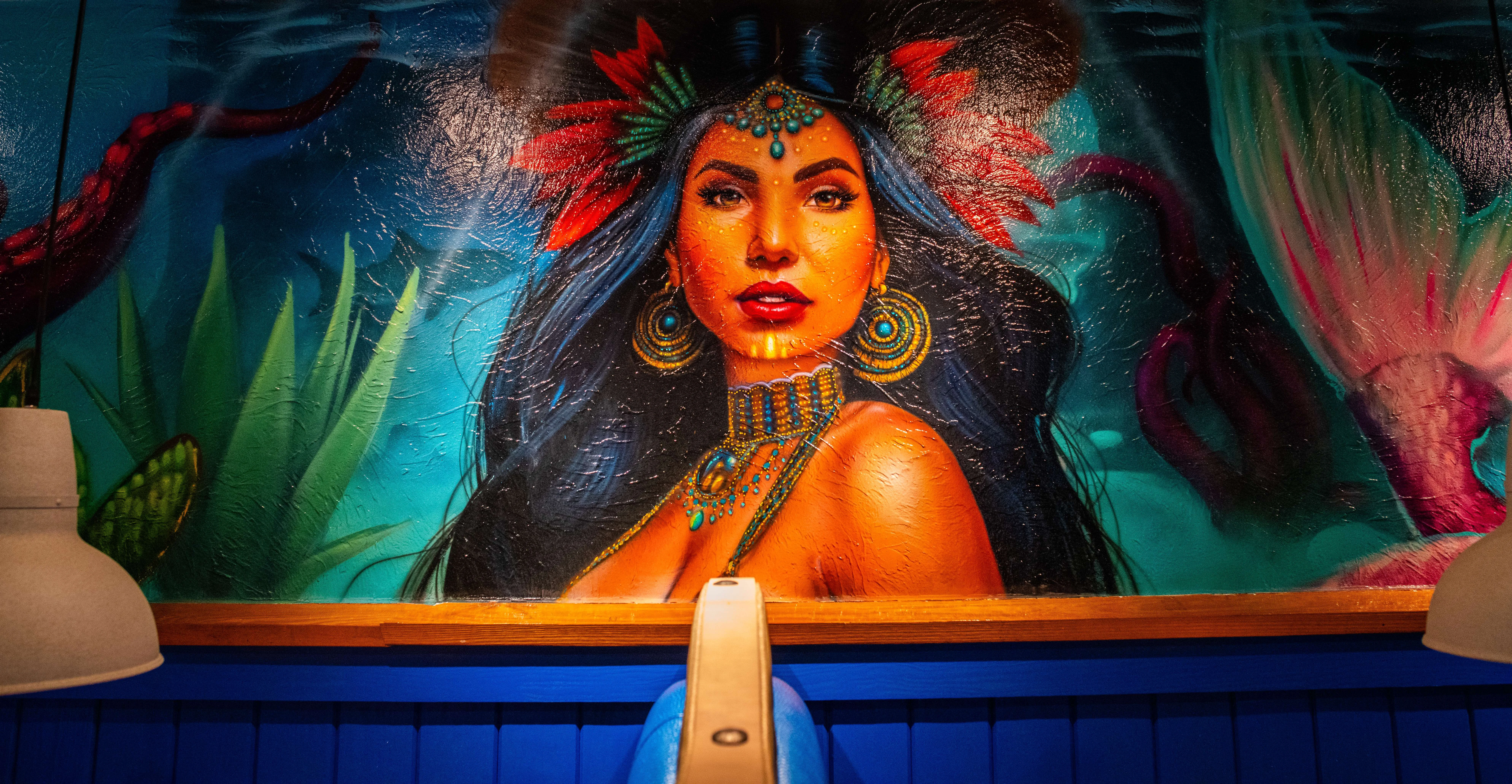 Vibrant mural of a woman with tropical elements in a restaurant