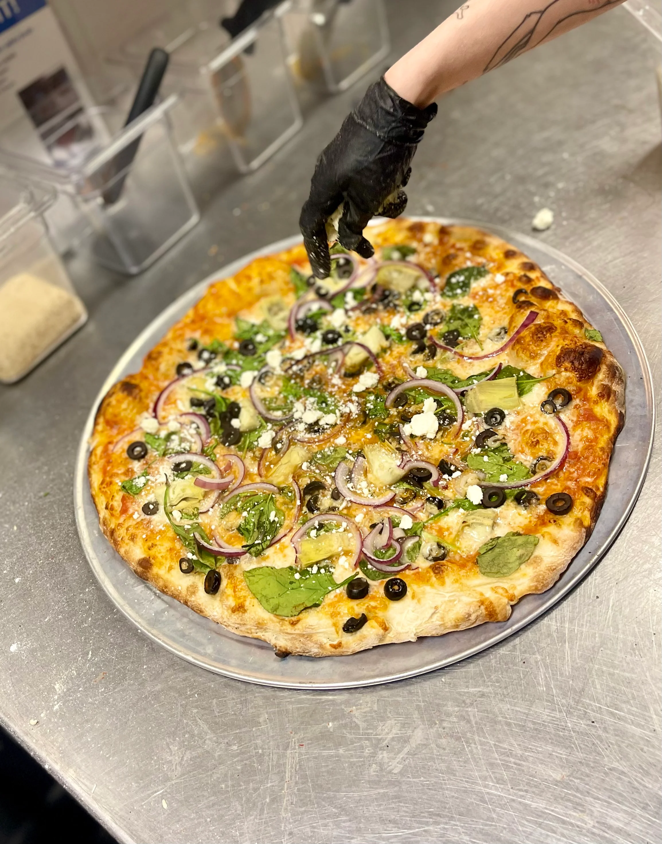 Vegetarian pizza topped with fresh greens and olives