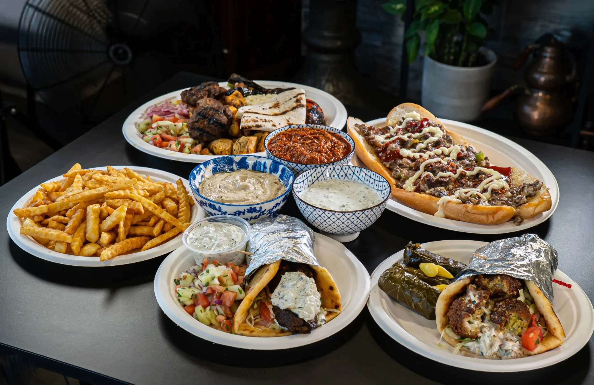 Assorted Mediterranean platters with kebabs, wraps, and fries