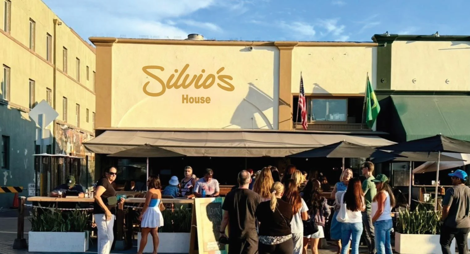 Outdoor bar area with seating and beach view at Bar Hermosa Beach.
