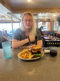 Juicy cheeseburger with curly fries in a casual diner setting