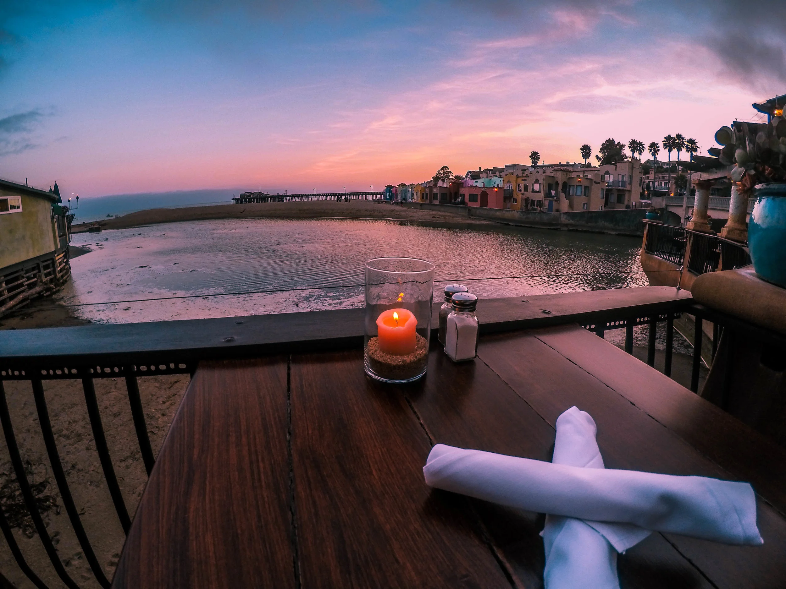 Scenic waterfront dining with candlelight at sunset