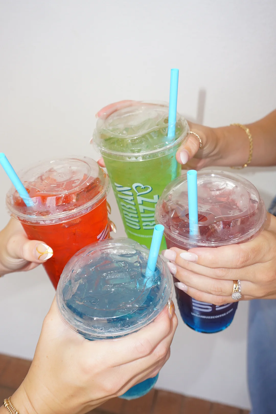 Colorful drinks in clear cups with straws for a refreshing summer vibe