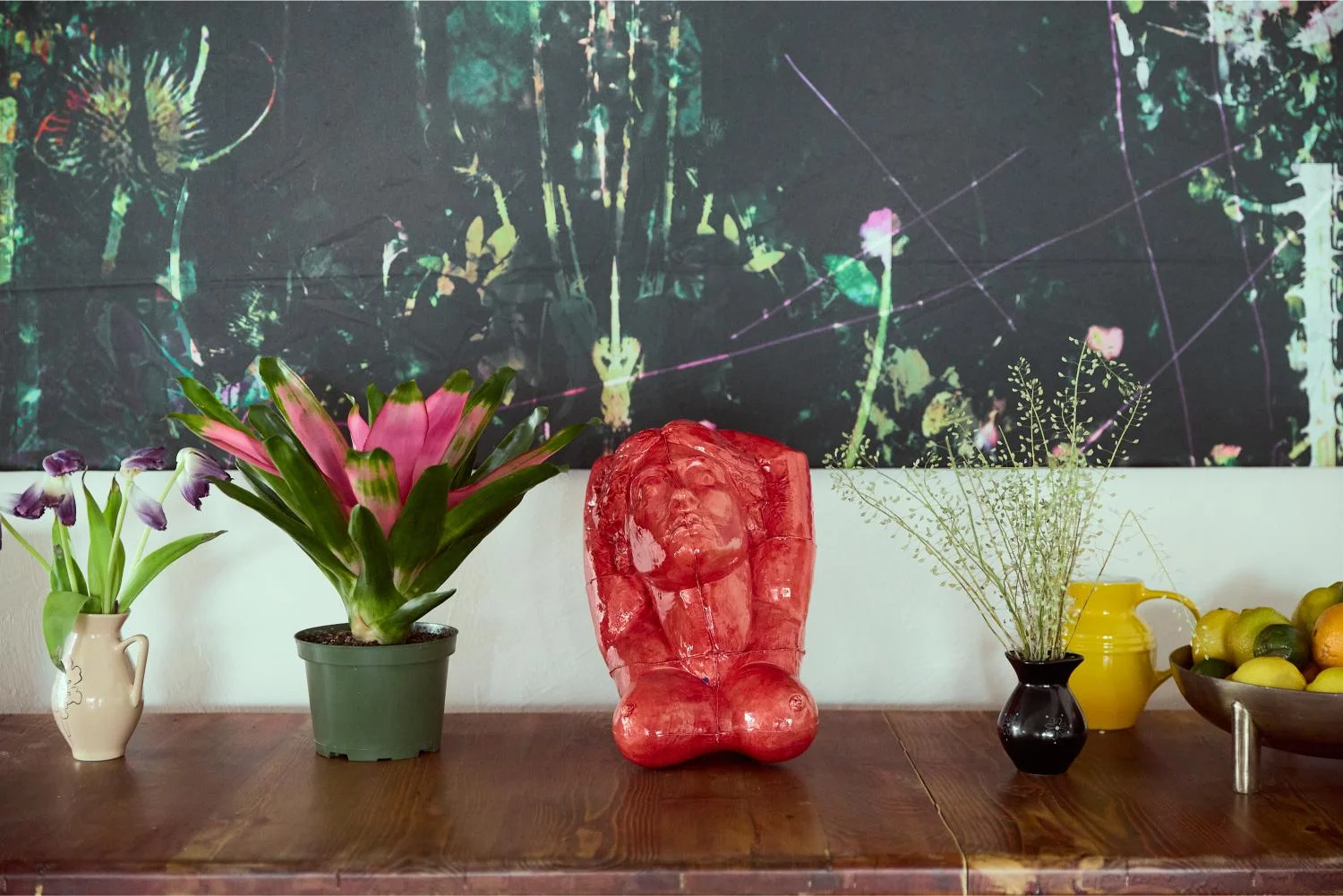 Artistic display of plants and sculpture on a wooden table