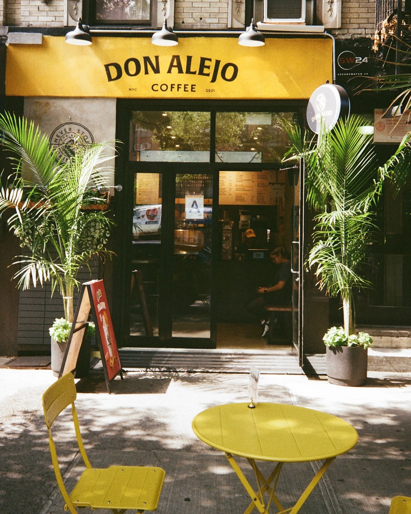 Charming coffee shop exterior with yellow accents and outdoor seating