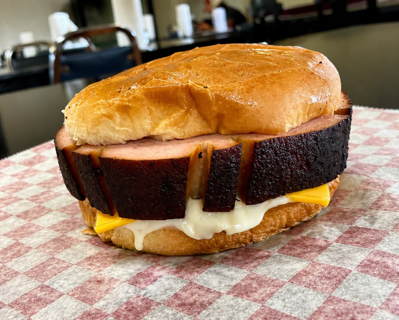 Smoked brisket sandwich with cheese on a toasted bun