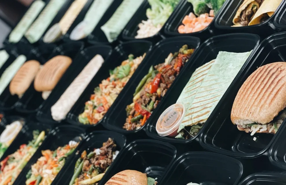 Assorted meal prep containers with wraps and salads
