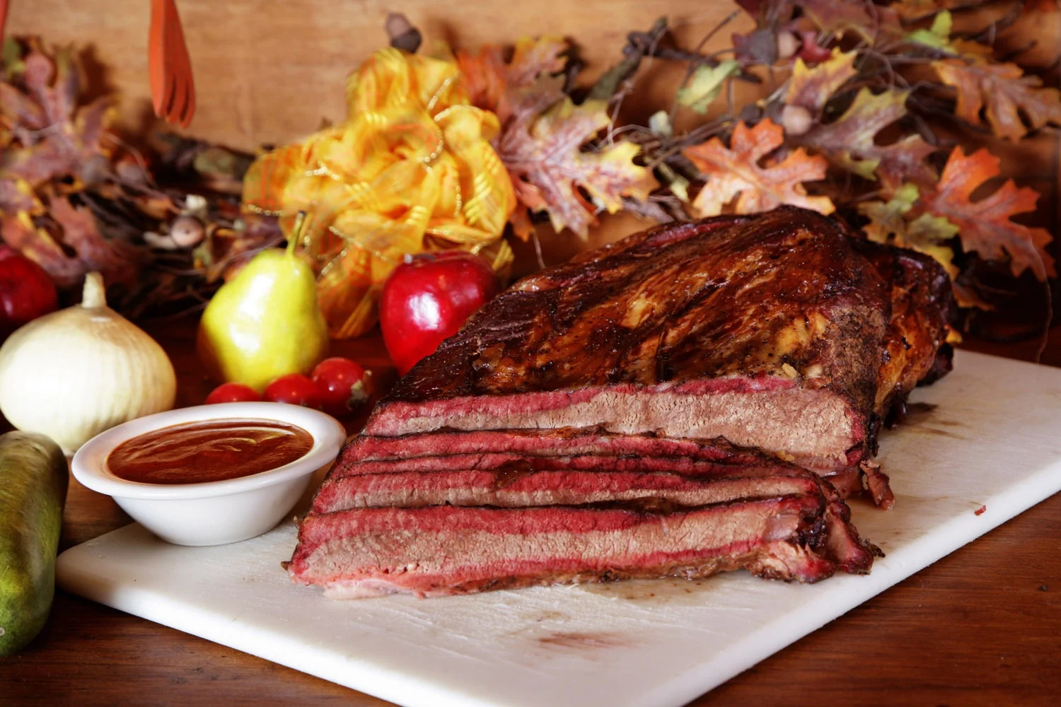 Sliced smoked brisket with barbecue sauce on a wooden table