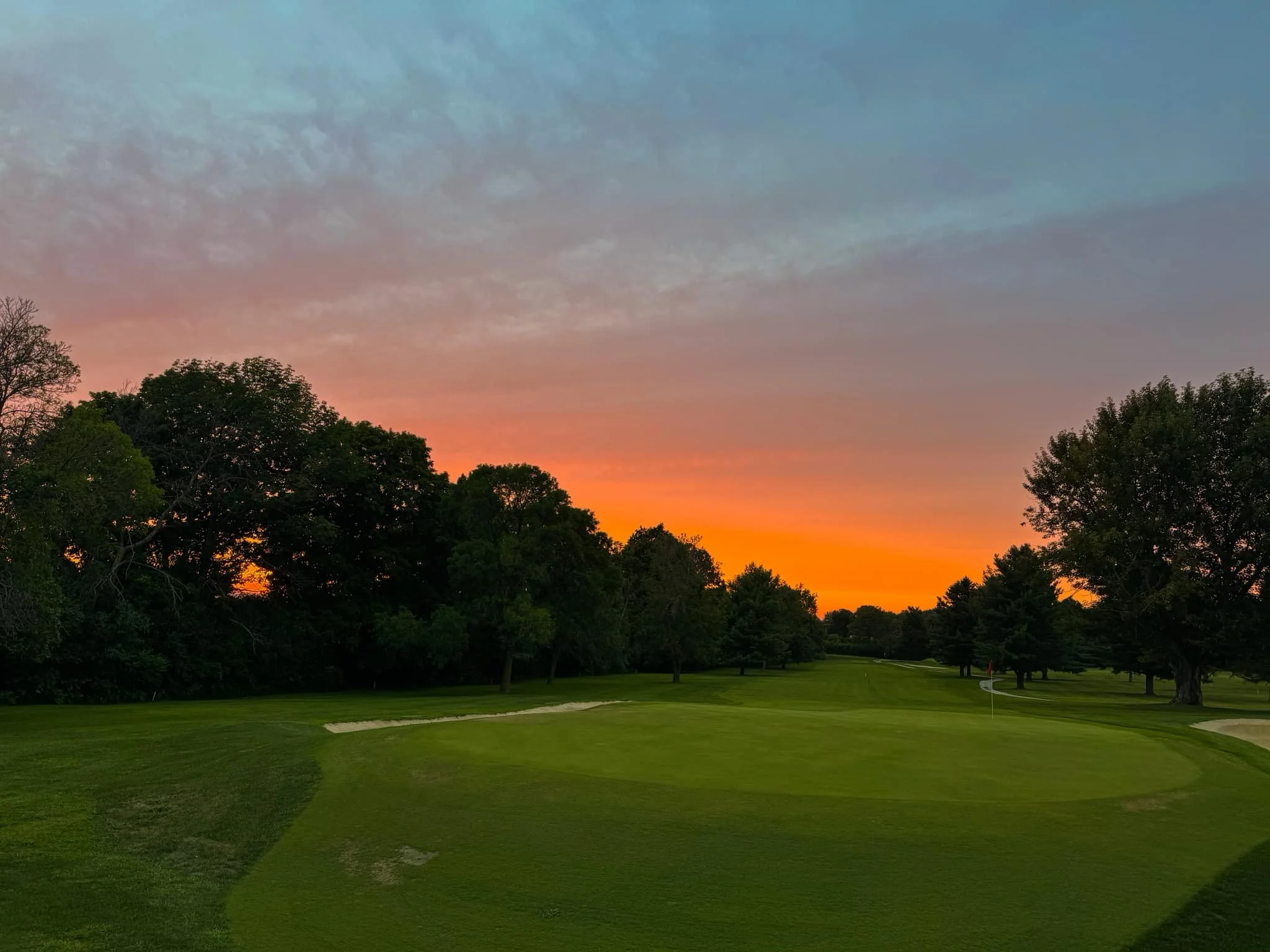 Beautiful sunset over a golf course with lush greenery