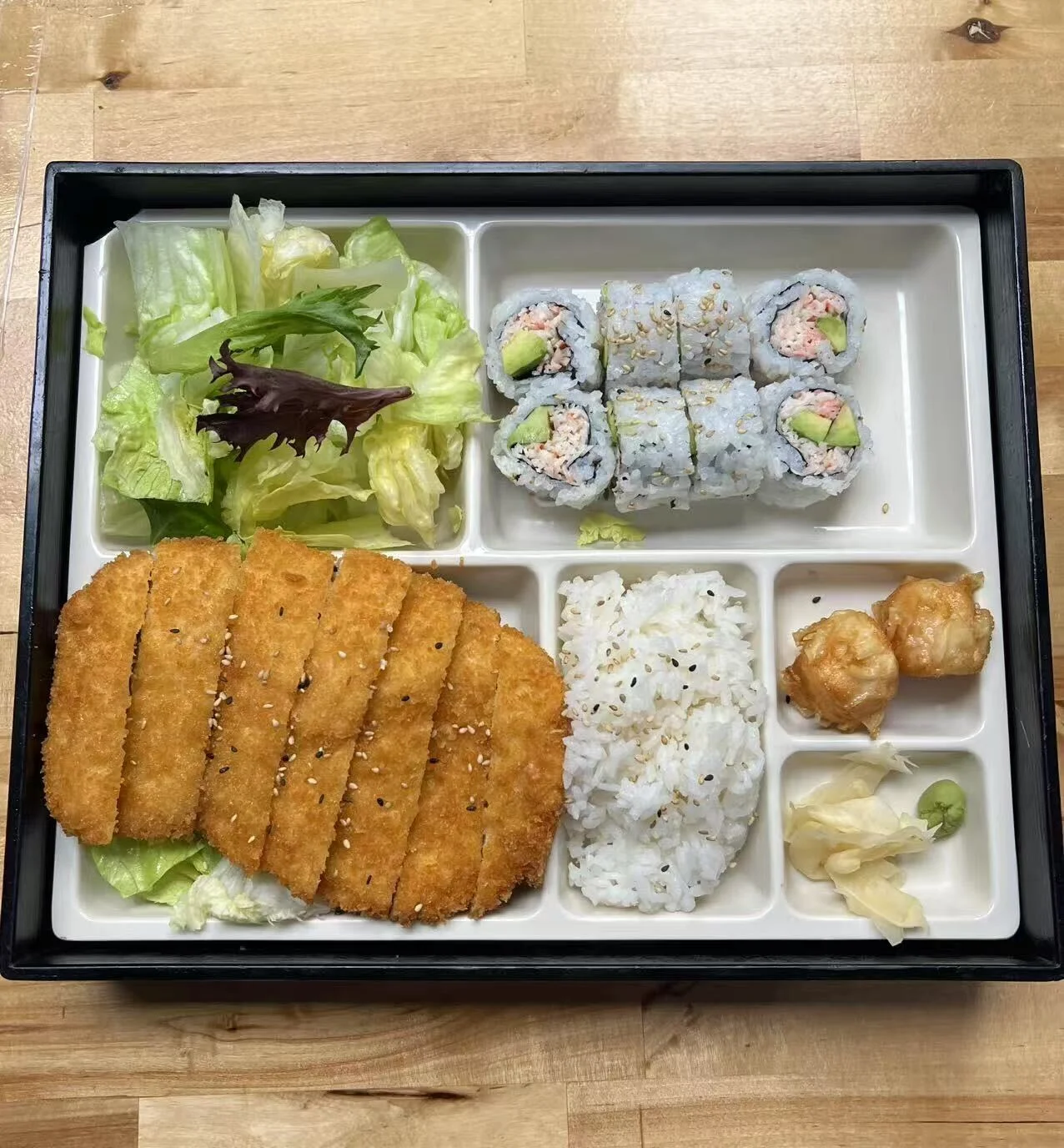 Japanese katsu bento box with sushi, rice, and salad