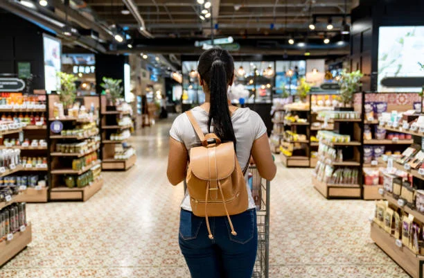 Woman shopping in a modern grocery store aisle