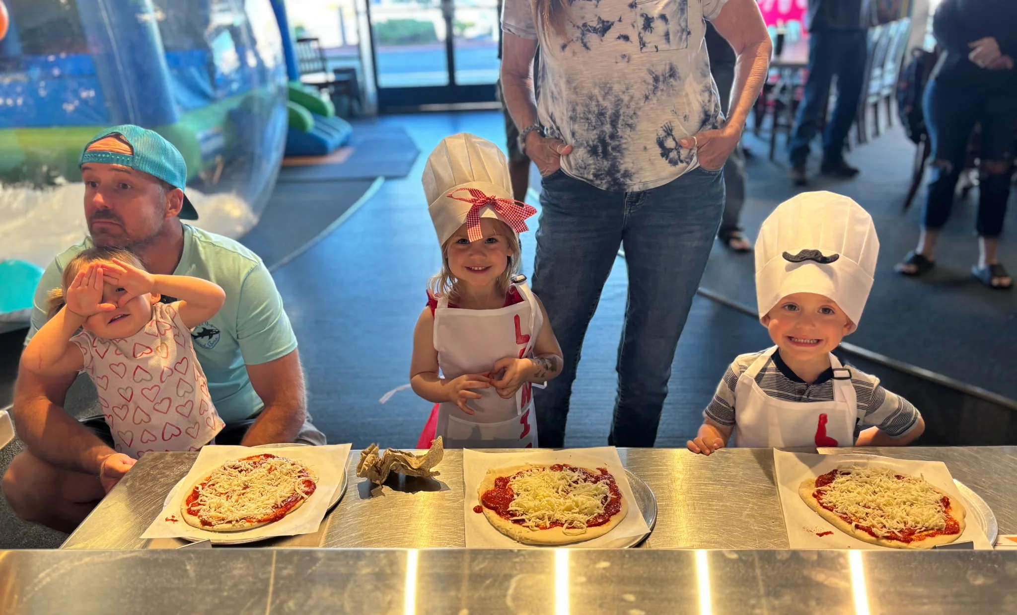 Kids making personal pizzas in a fun restaurant setting