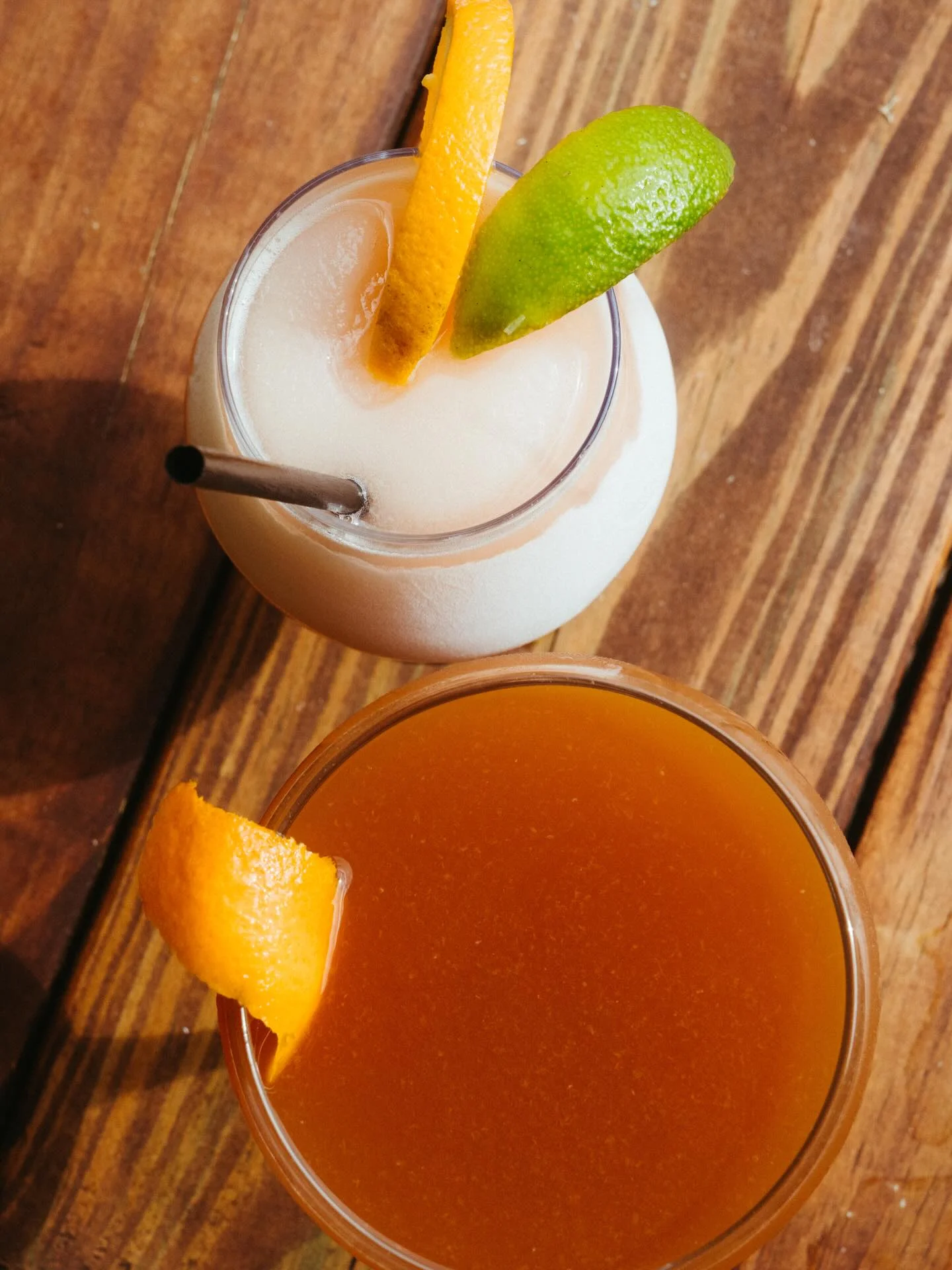 Refreshing cocktails with citrus garnishes on a wooden table