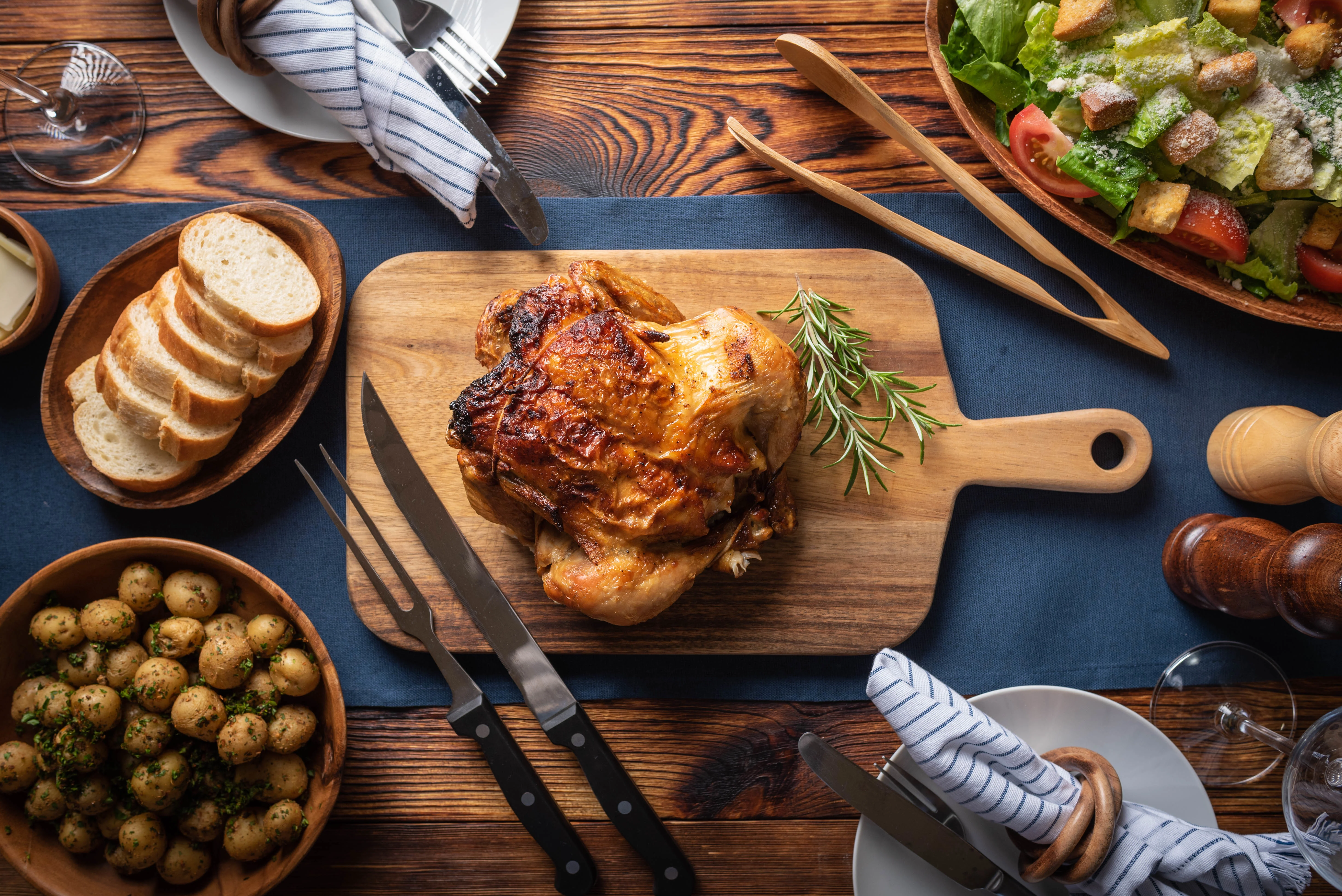 Roast chicken served with sides in a rustic dining setting