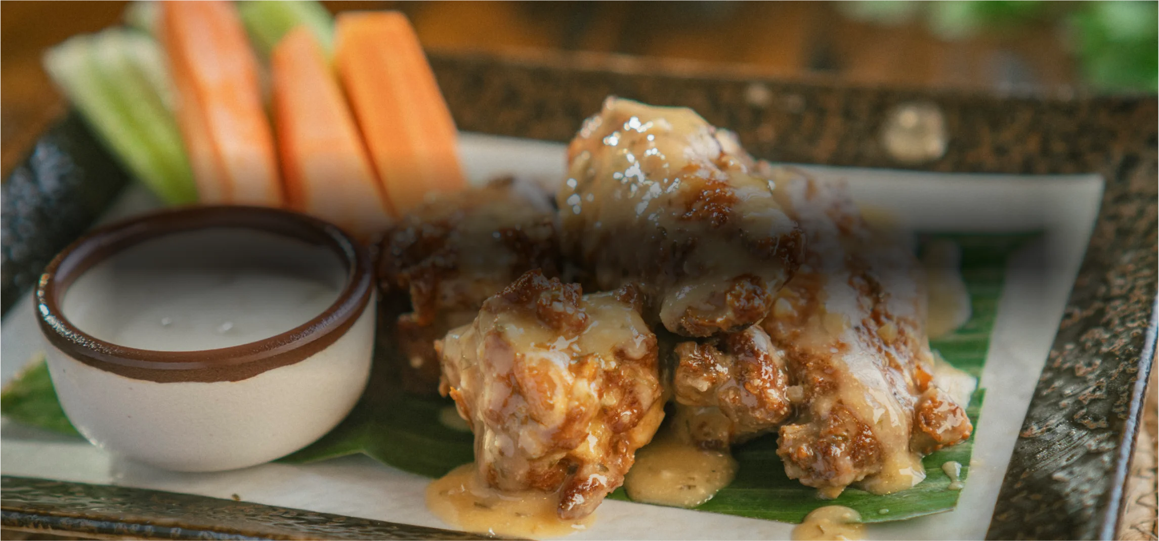 Crispy chicken wings with creamy sauce and fresh vegetable sticks