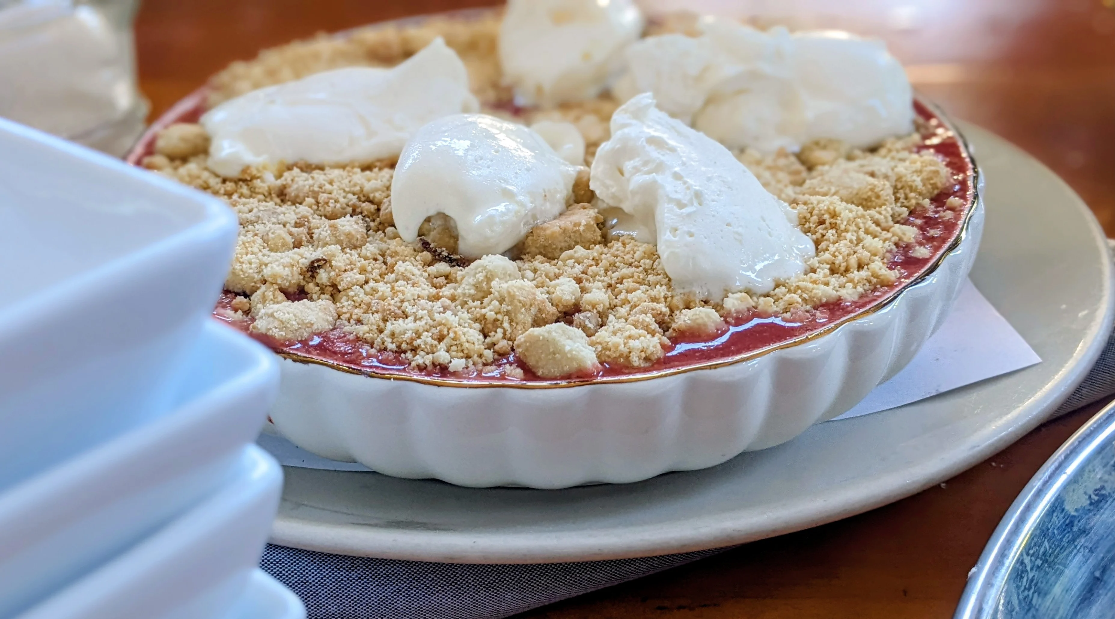 Delicious berry crumble dessert topped with whipped cream