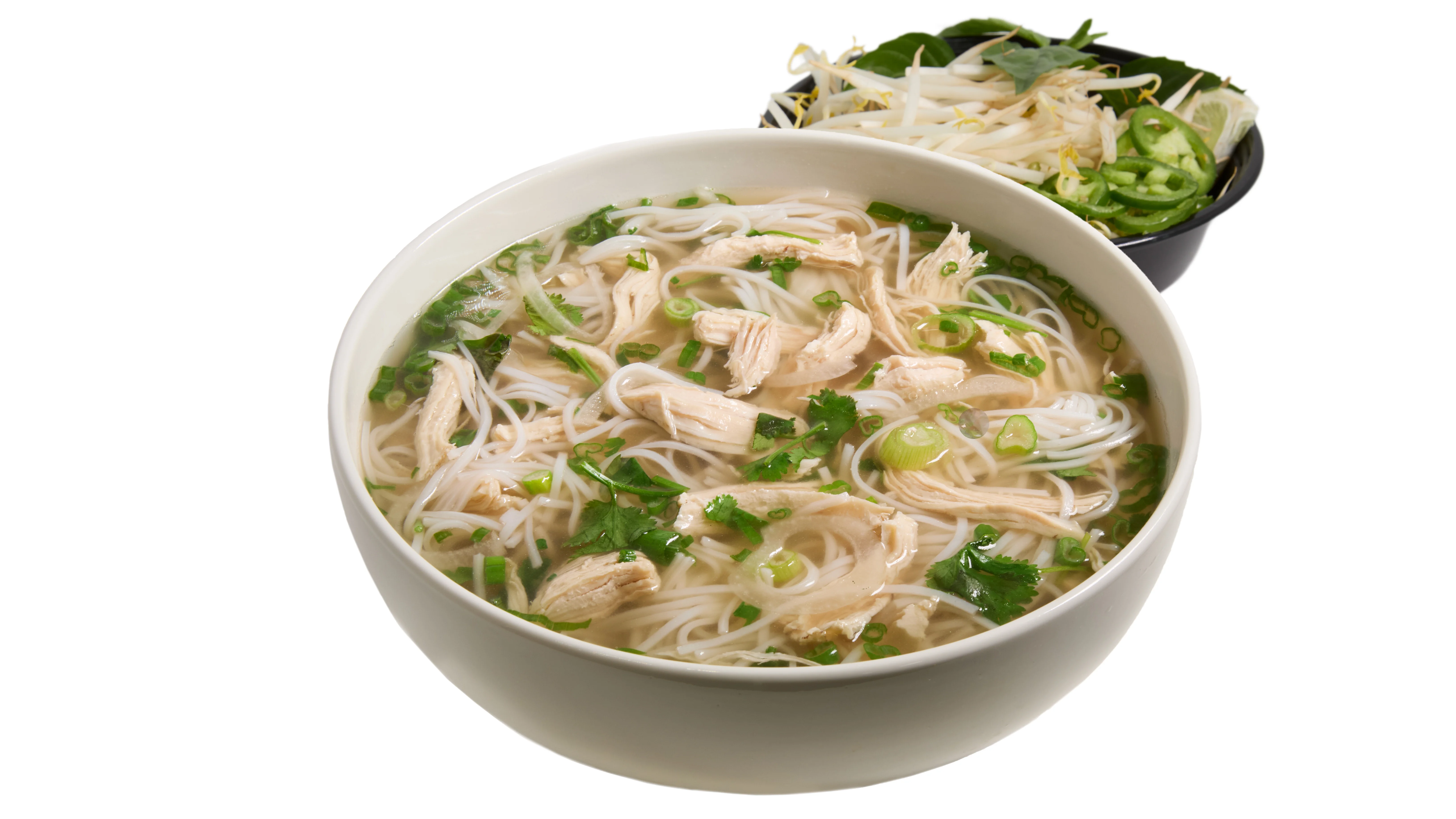 A bowl of Yoki Chicken Noodle soup with fresh ingredients.