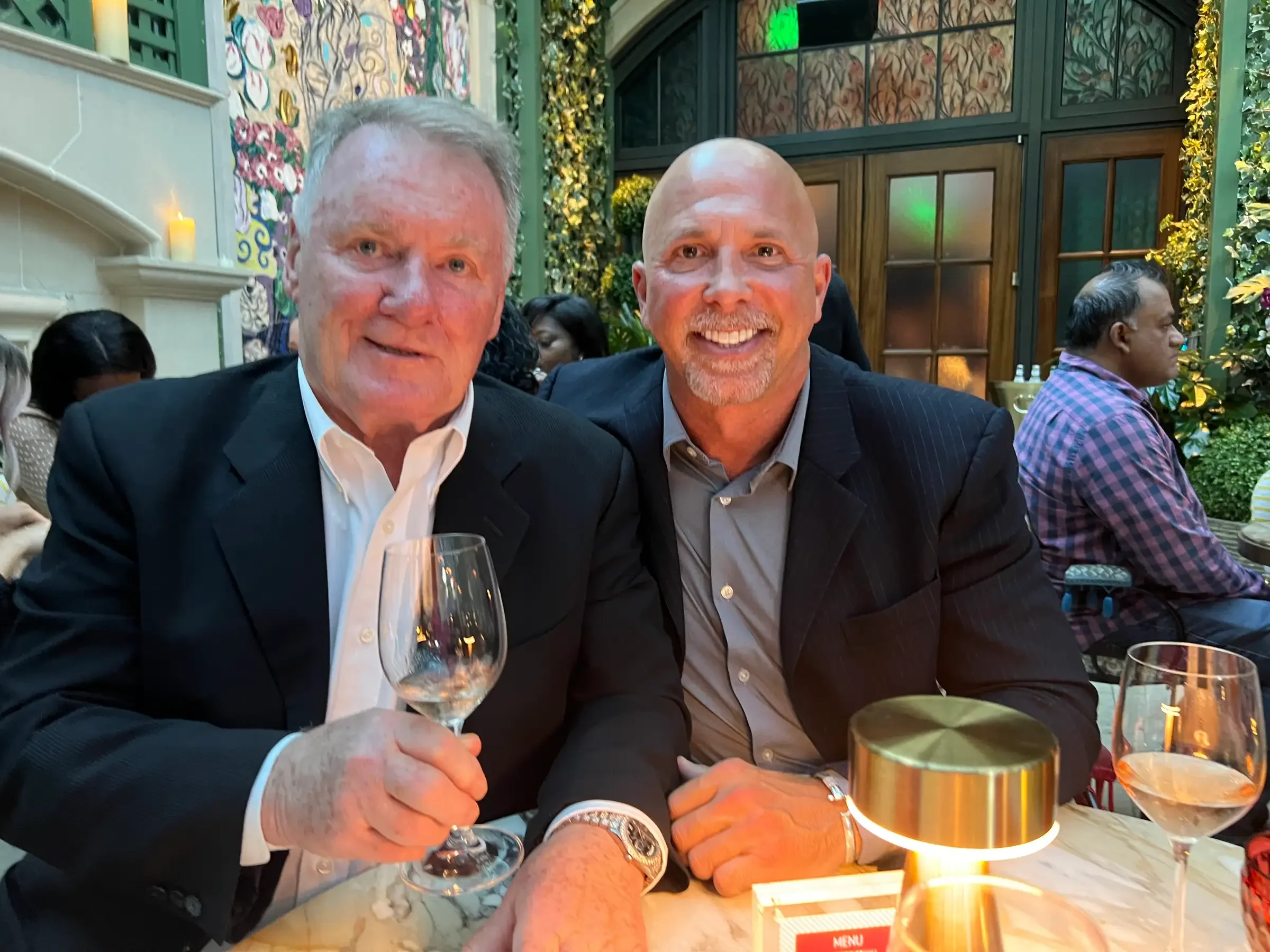 Two men enjoying drinks in a stylish restaurant setting