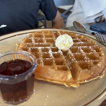 Golden Belgian waffle with butter and syrup