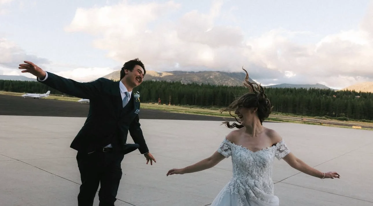 Joyful couple dancing outdoors in wedding attire