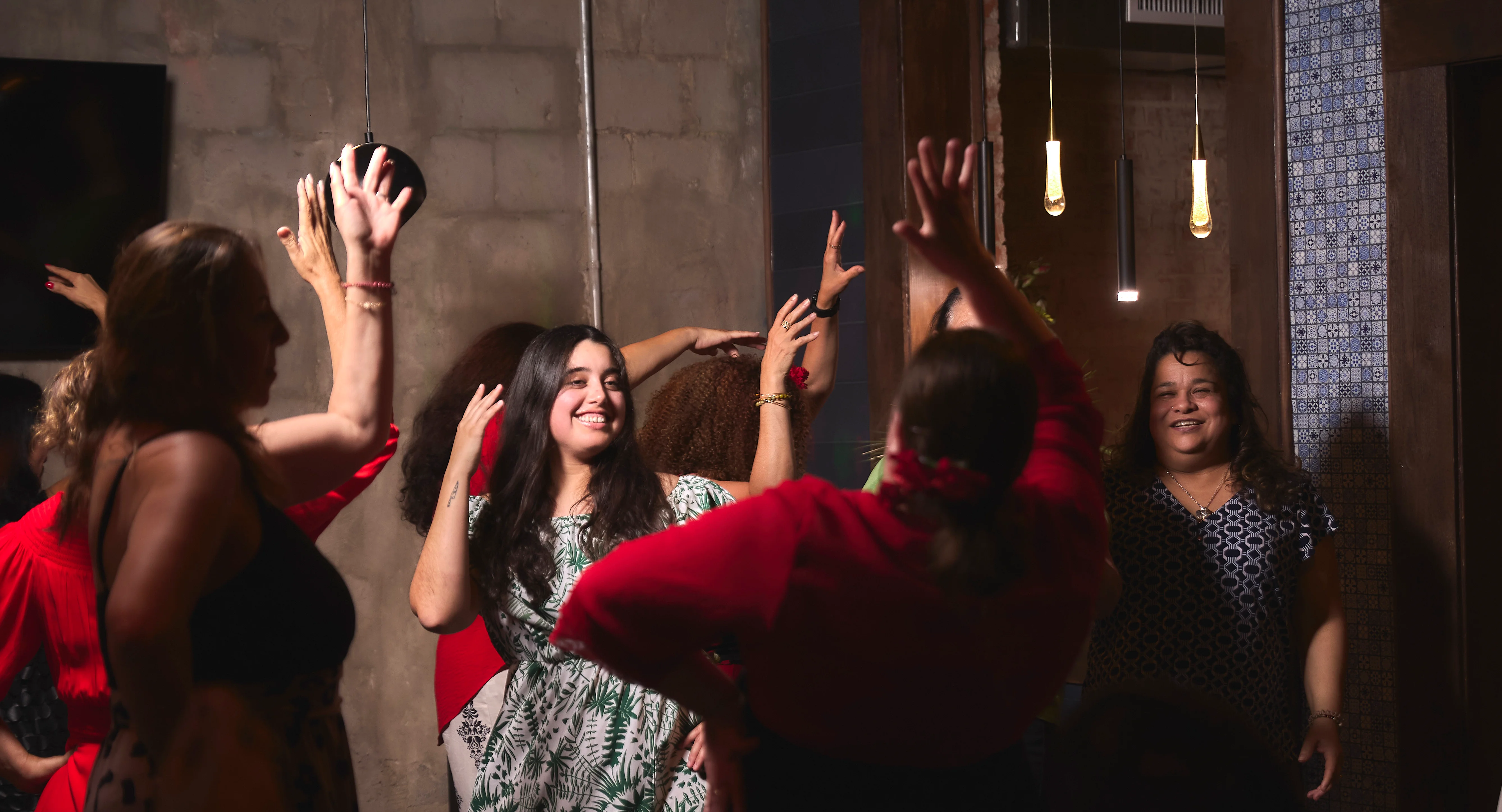 Group of friends dancing joyfully in a lively restaurant setting