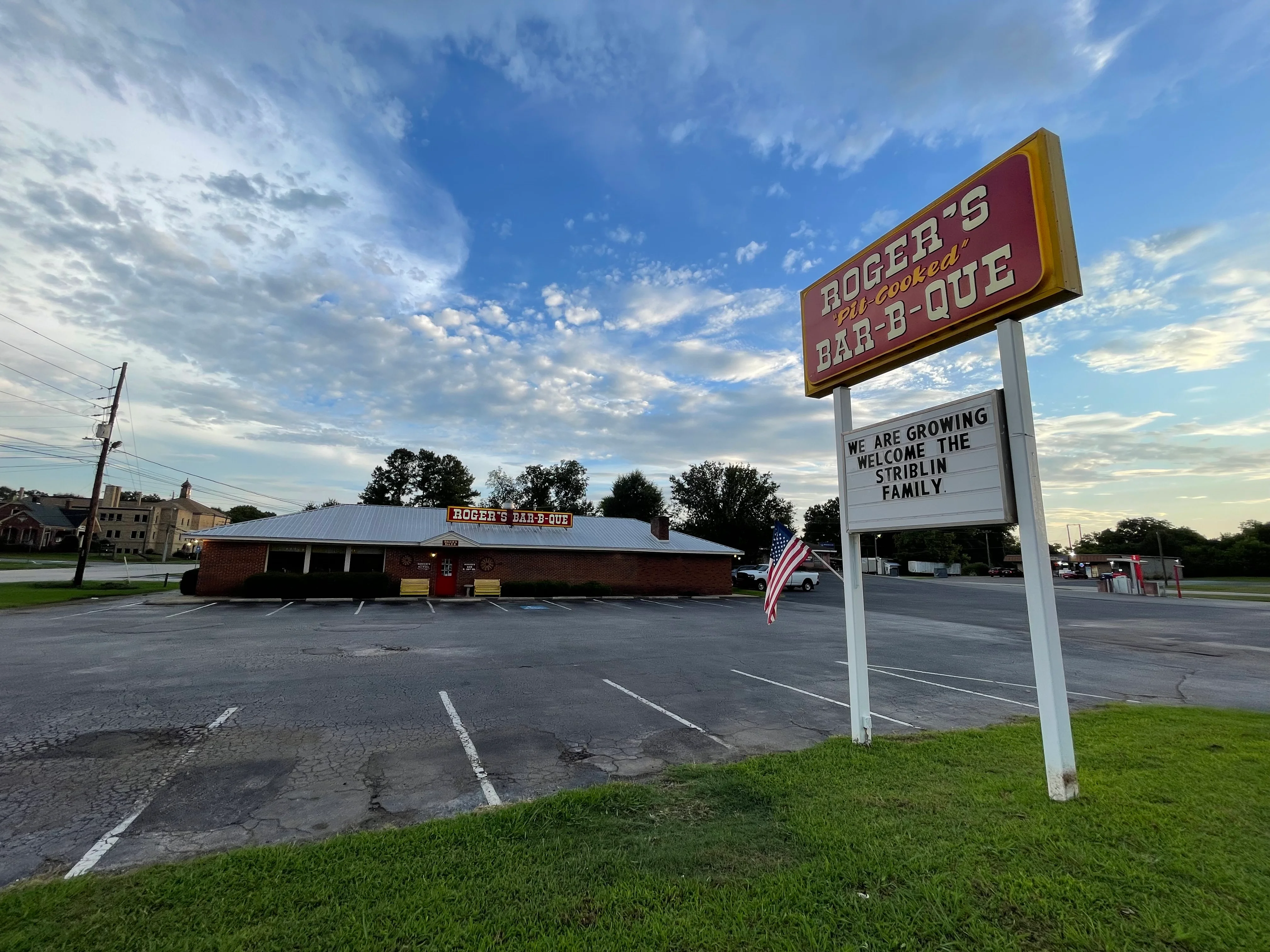 Exterior view of Roger's Bar-B-Que restaurant with welcoming sign