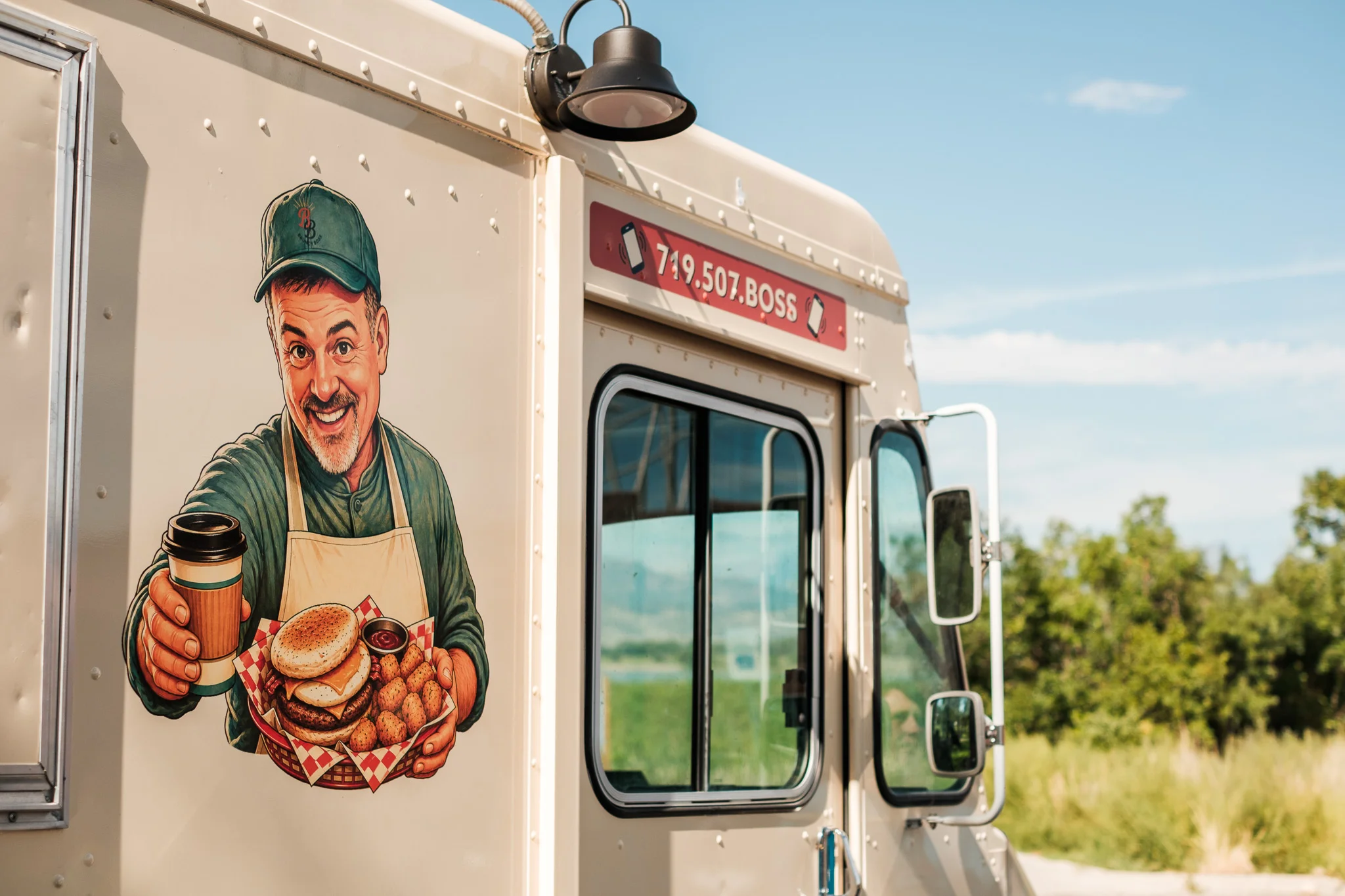 Food truck featuring a smiling chef with burgers and coffee