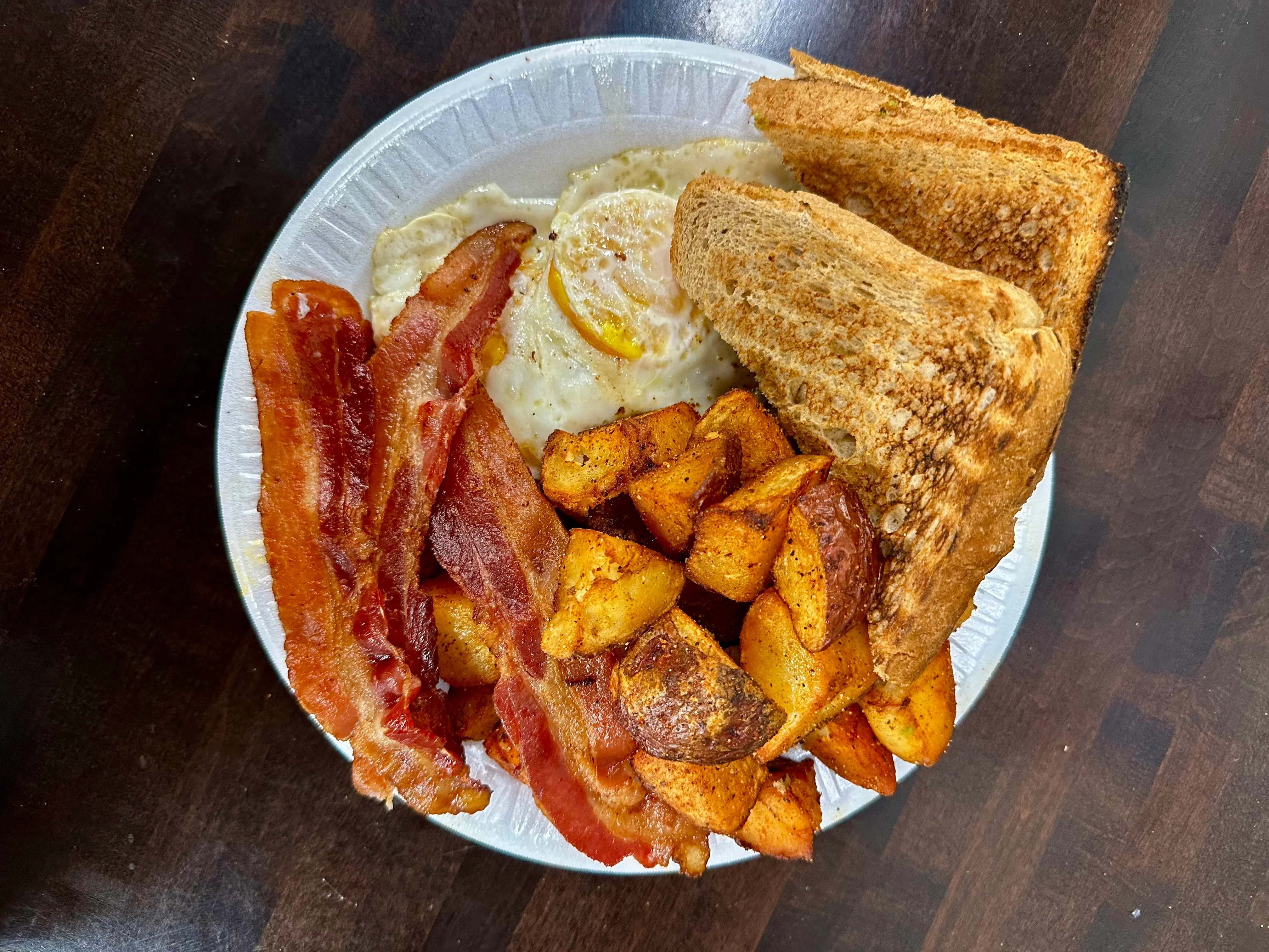 Classic American breakfast platter with eggs, bacon, and toast