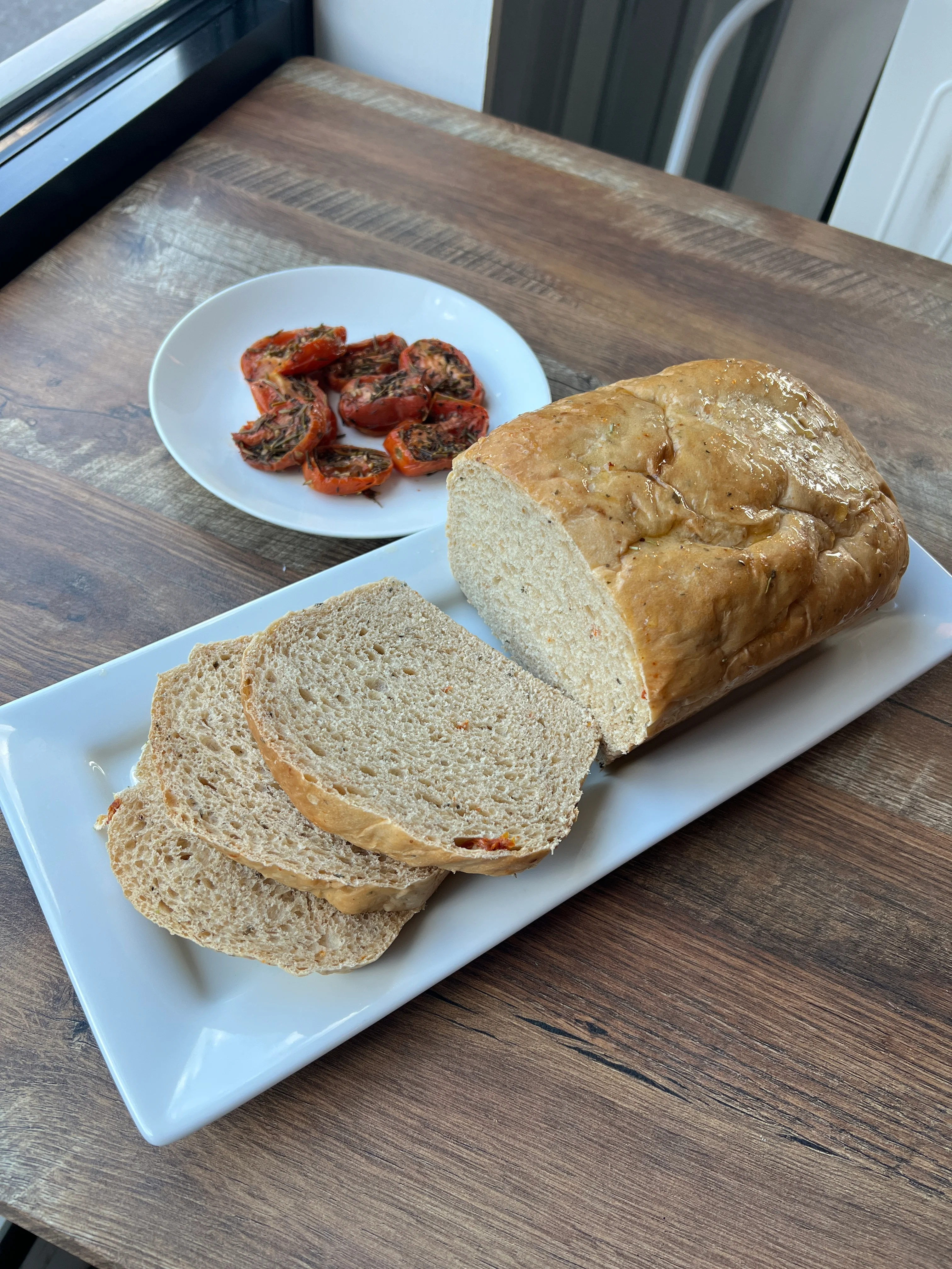 Freshly baked whole grain bread with roasted tomatoes on a plate