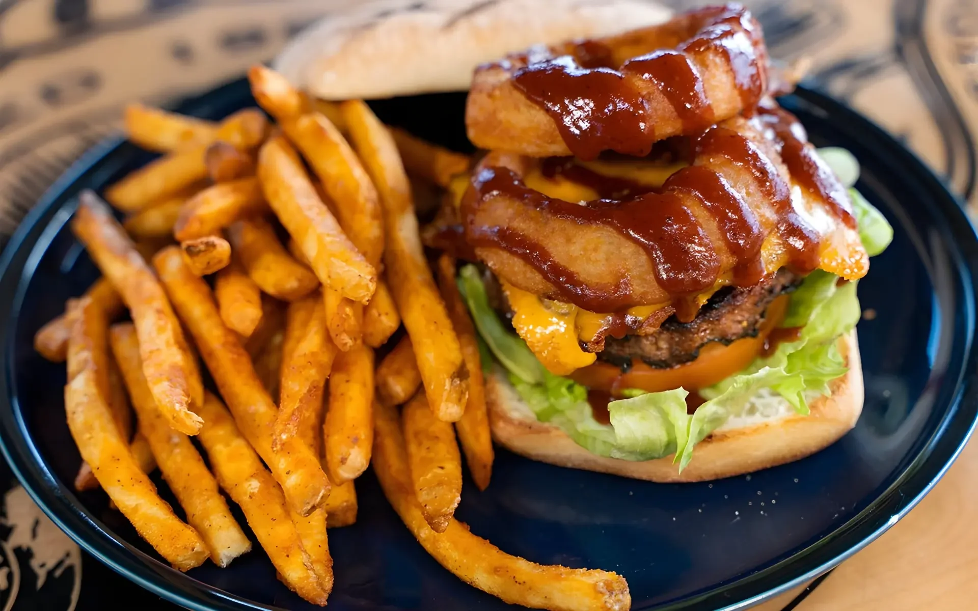 Juicy American cheeseburger with onion rings and fries