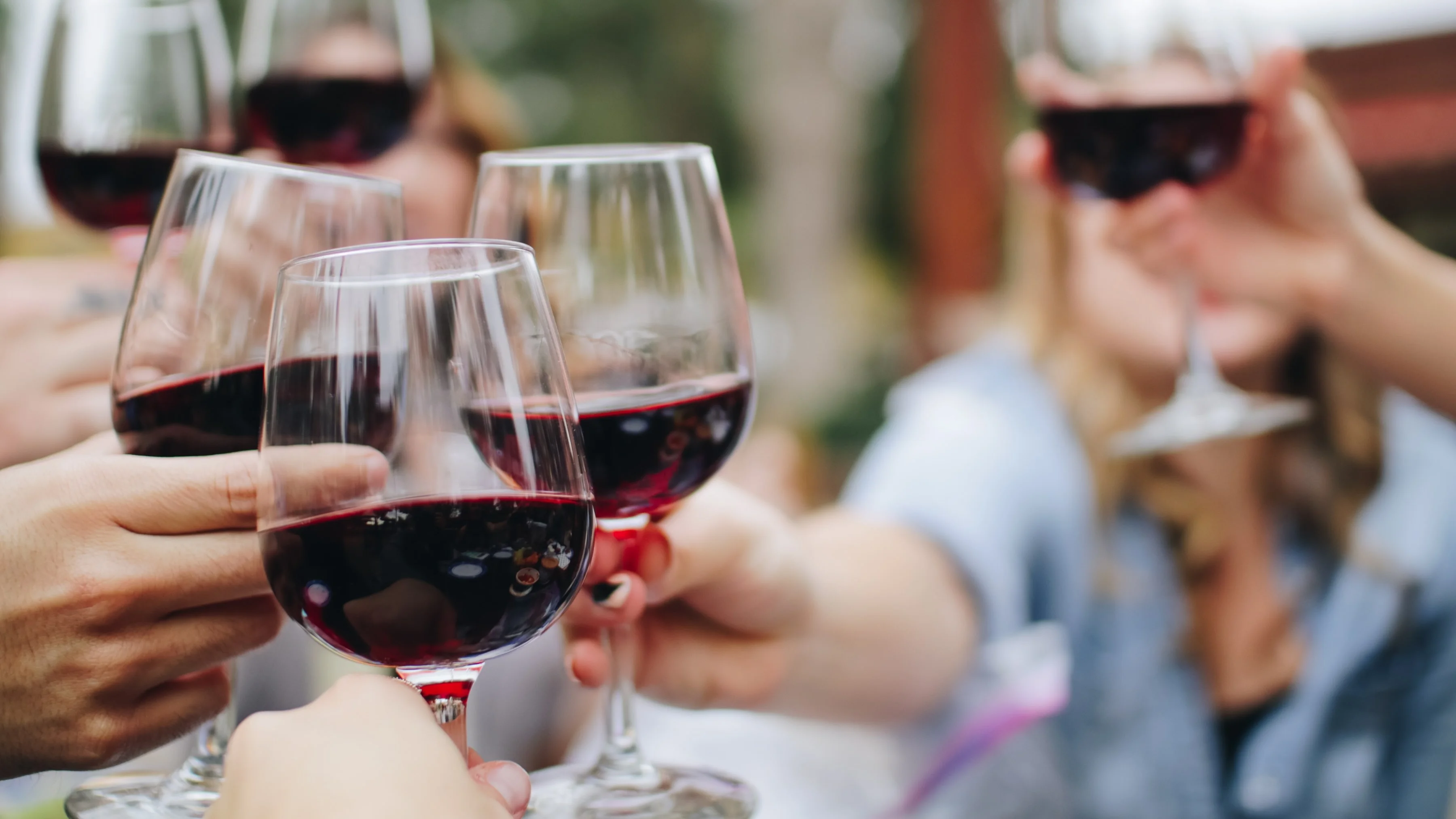 Cheers with red wine glasses in a festive gathering