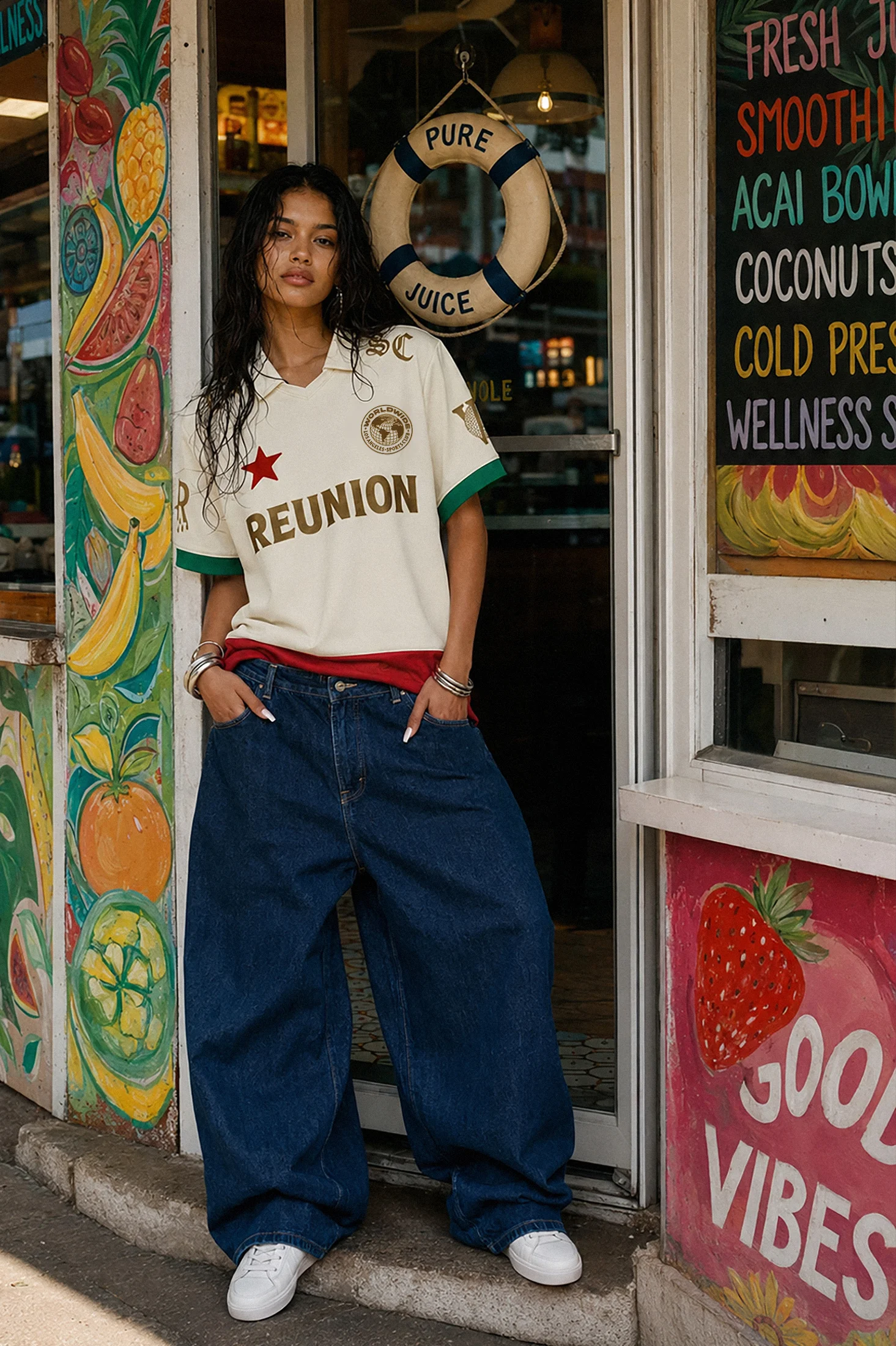 Fashionable model in oversized jeans and vintage jersey outside a juice bar