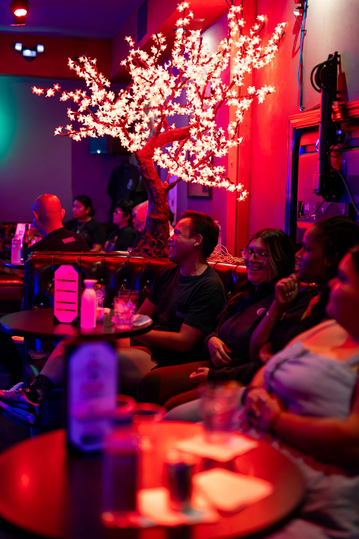 Cozy restaurant interior with vibrant lighting and decorative tree